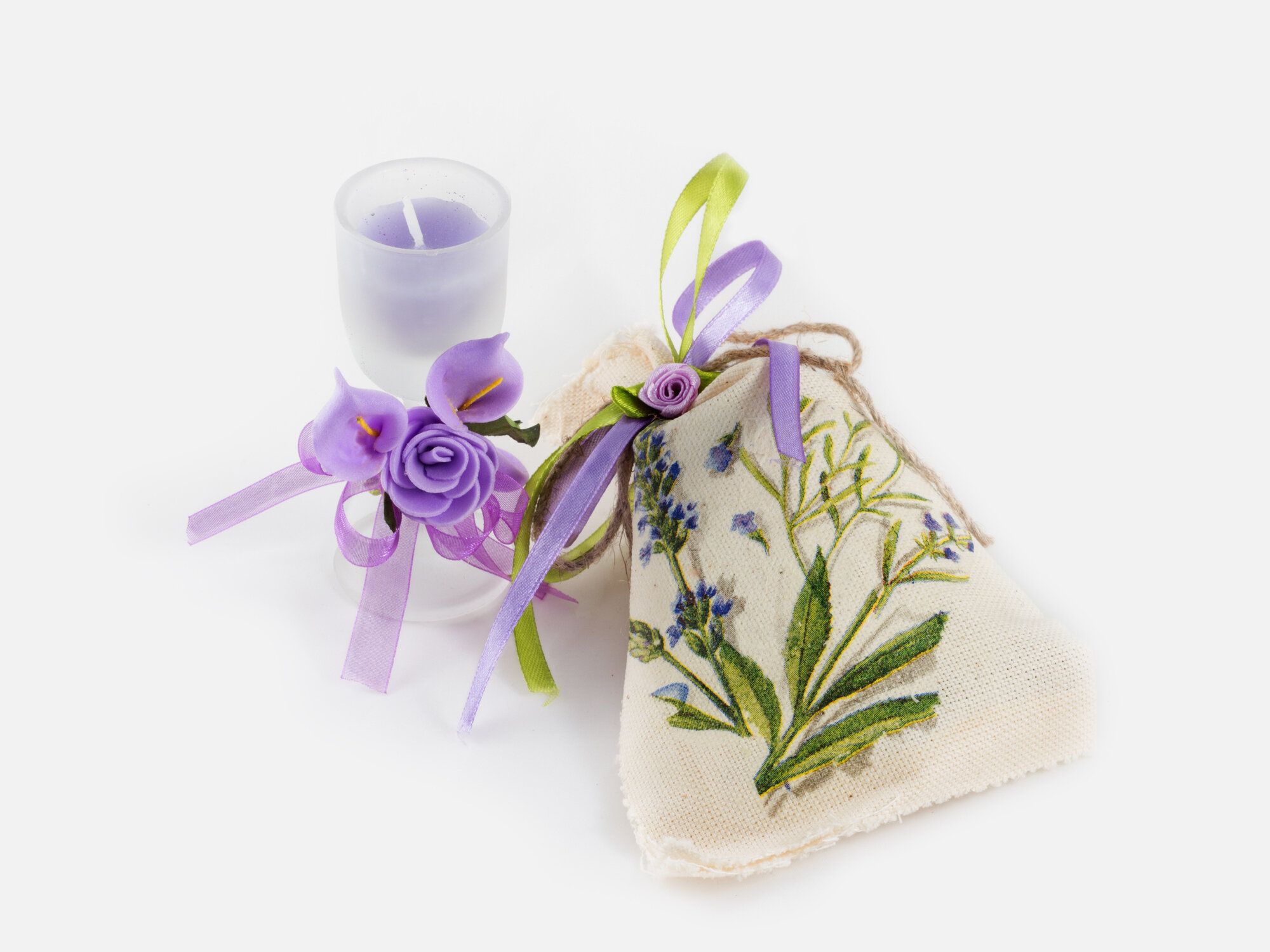 手作りリネン袋と香り付きキャンドル グラスは、白い背景の上人工の花で飾られました。