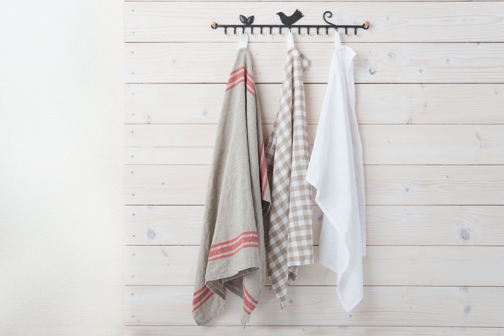 緑のボケの背景に赤いチェックのテーブルクロスが付いた空の木製のテーブル。春とイースターはデザインのためにモックアップ。