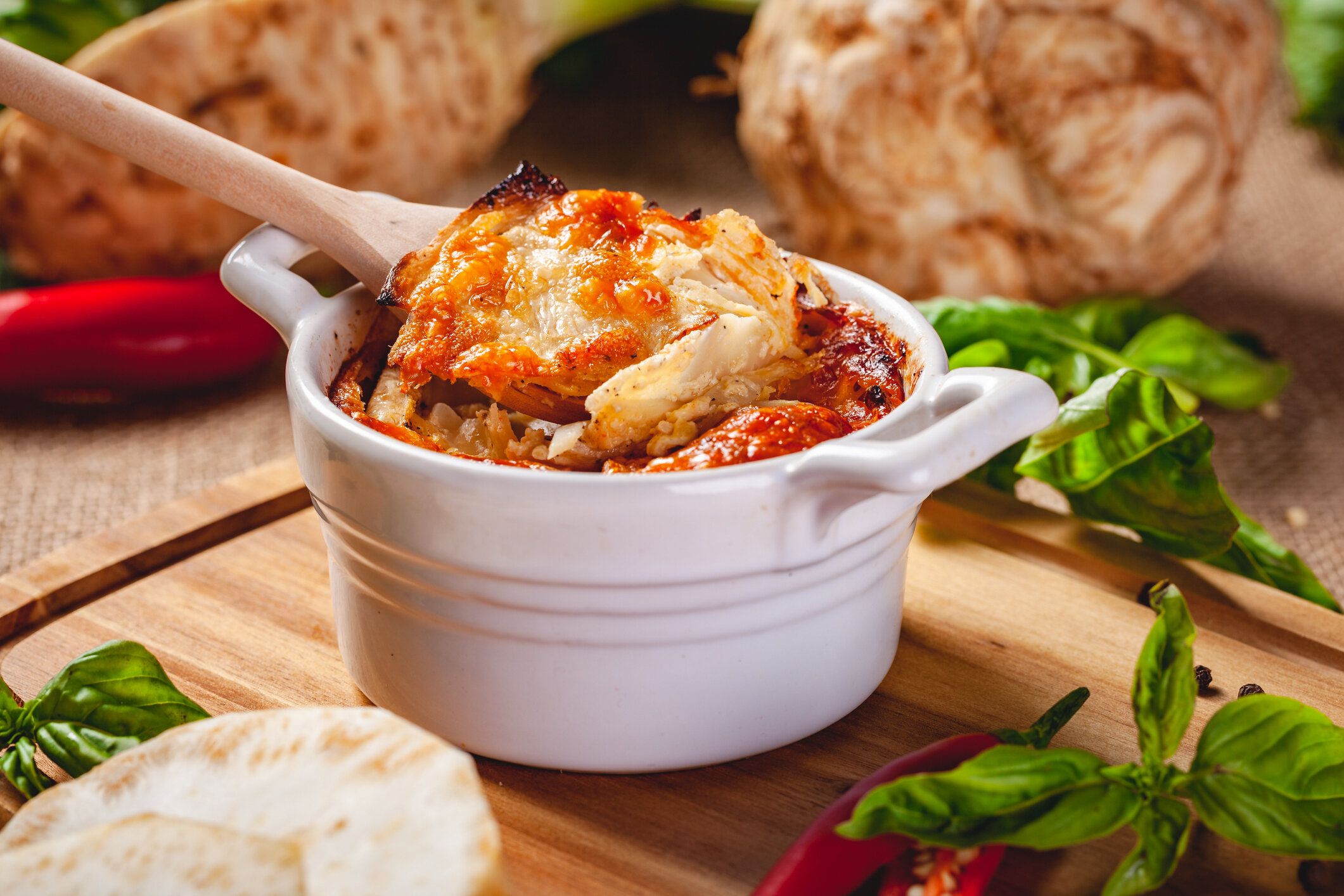 木製のボード上のチーズとキノコとセロリの根グラタン。クローズアップ