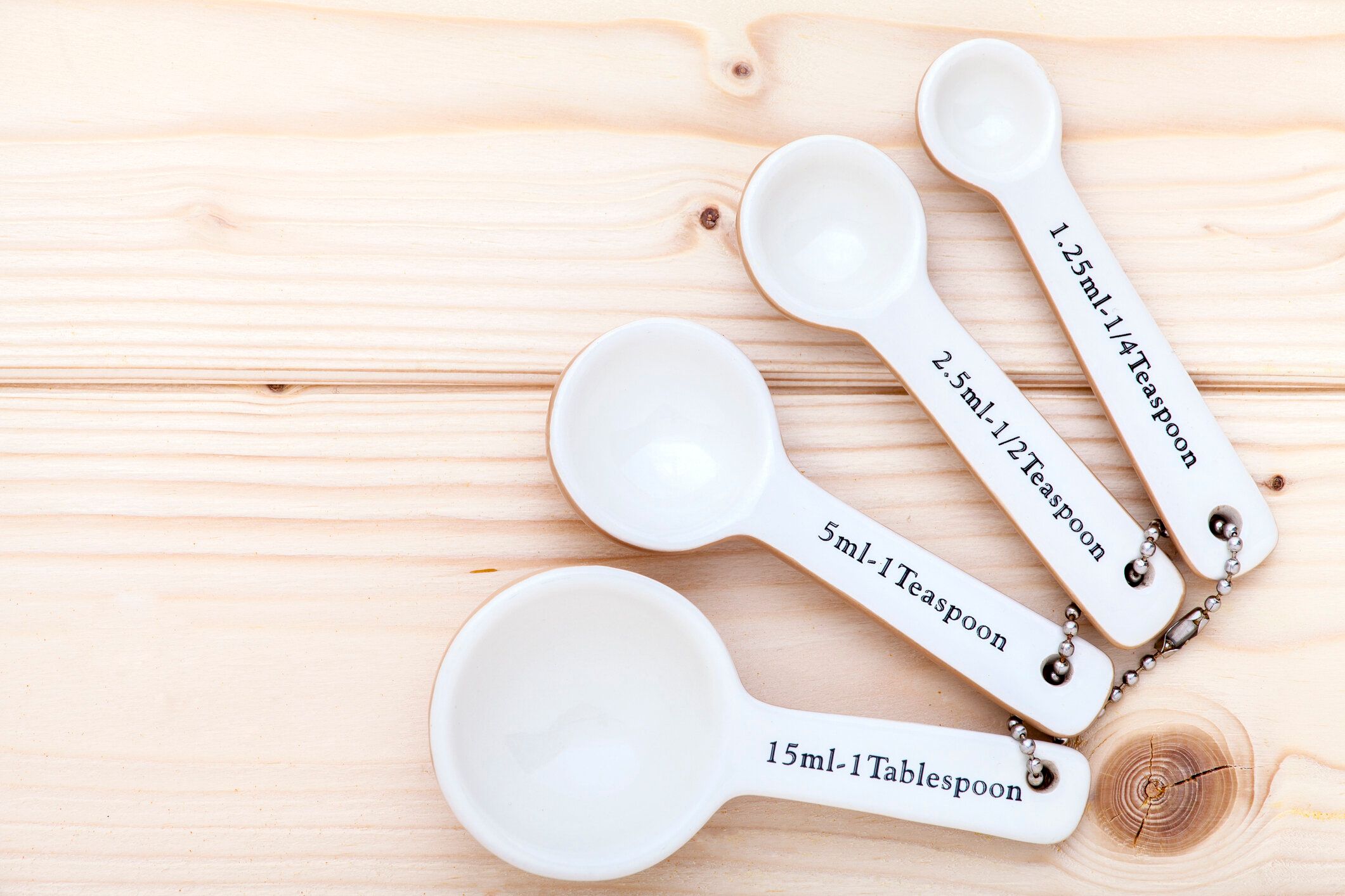 セラミック測定スプーンにパインウッドの背景上から見た。