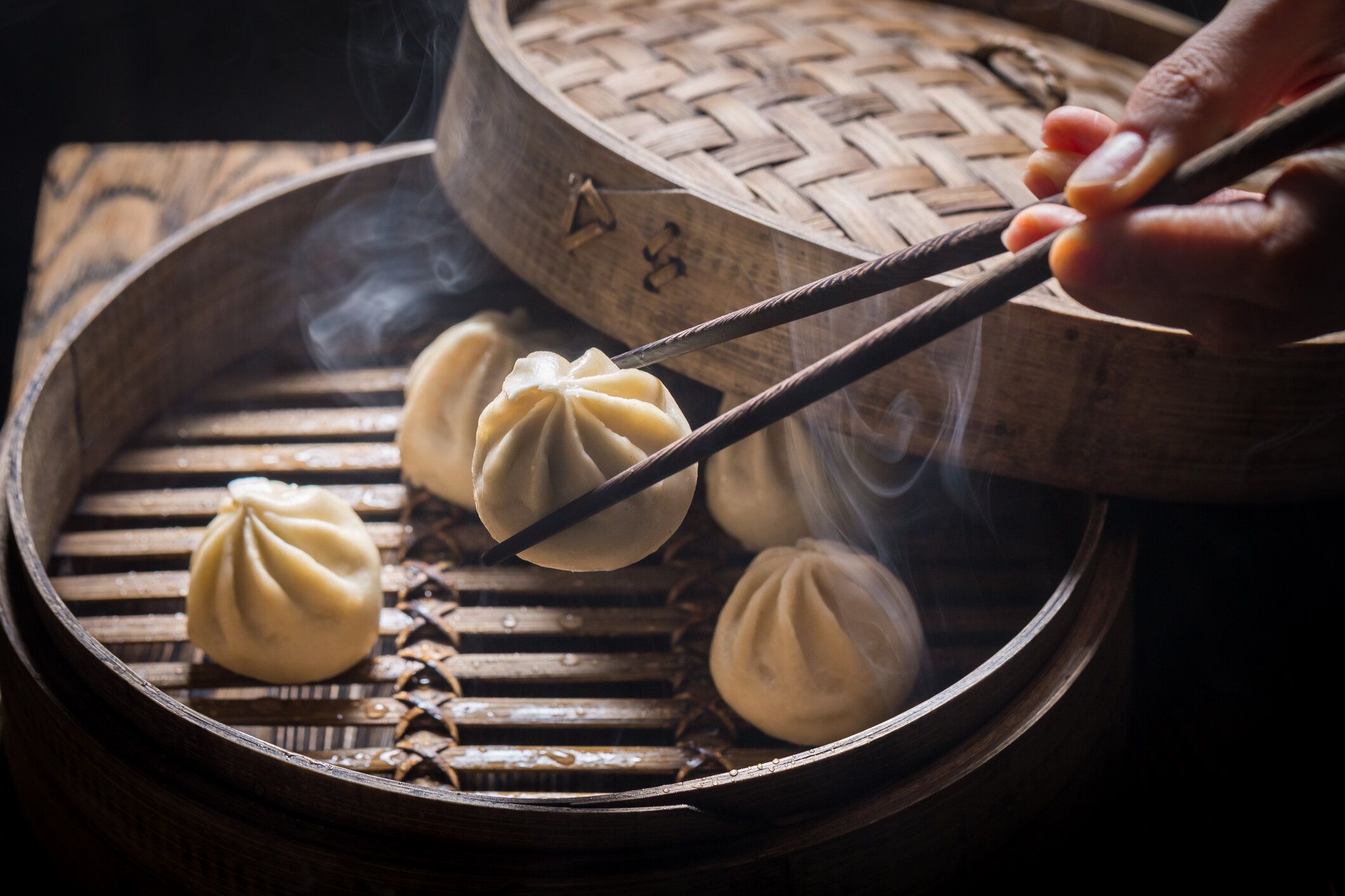 黒の背景に木製蒸し器に餃子のクローズ アップ