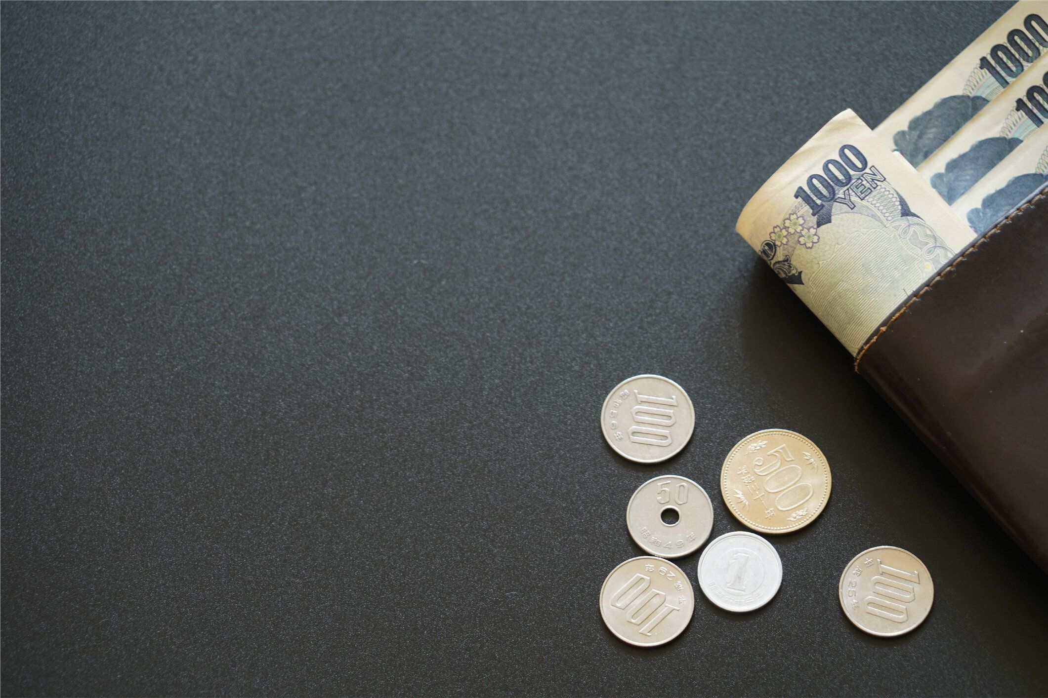 暗い背景、銀行経済金融概念、日本のお金の節約に財布の中の日本の紙幣とコイン