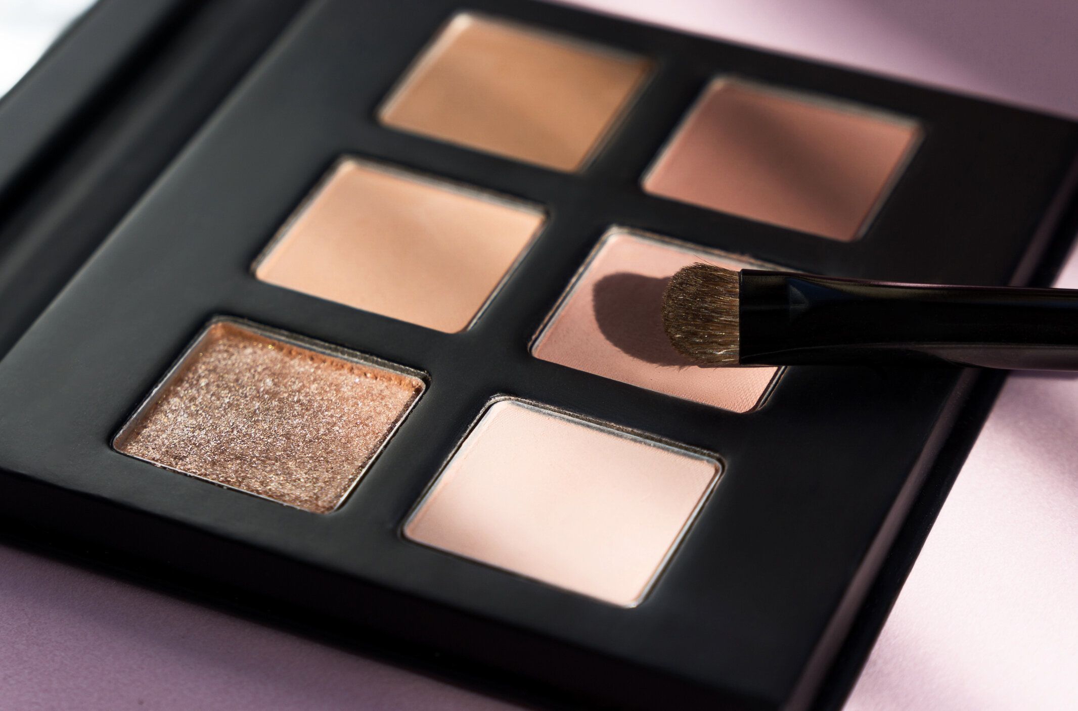 メイクアップアイシャドウパレットセット。トレンディなアイシャドウメイクアップパレットの背景、アイシャドウブラシクローズアップ。アイシャドウの背景。