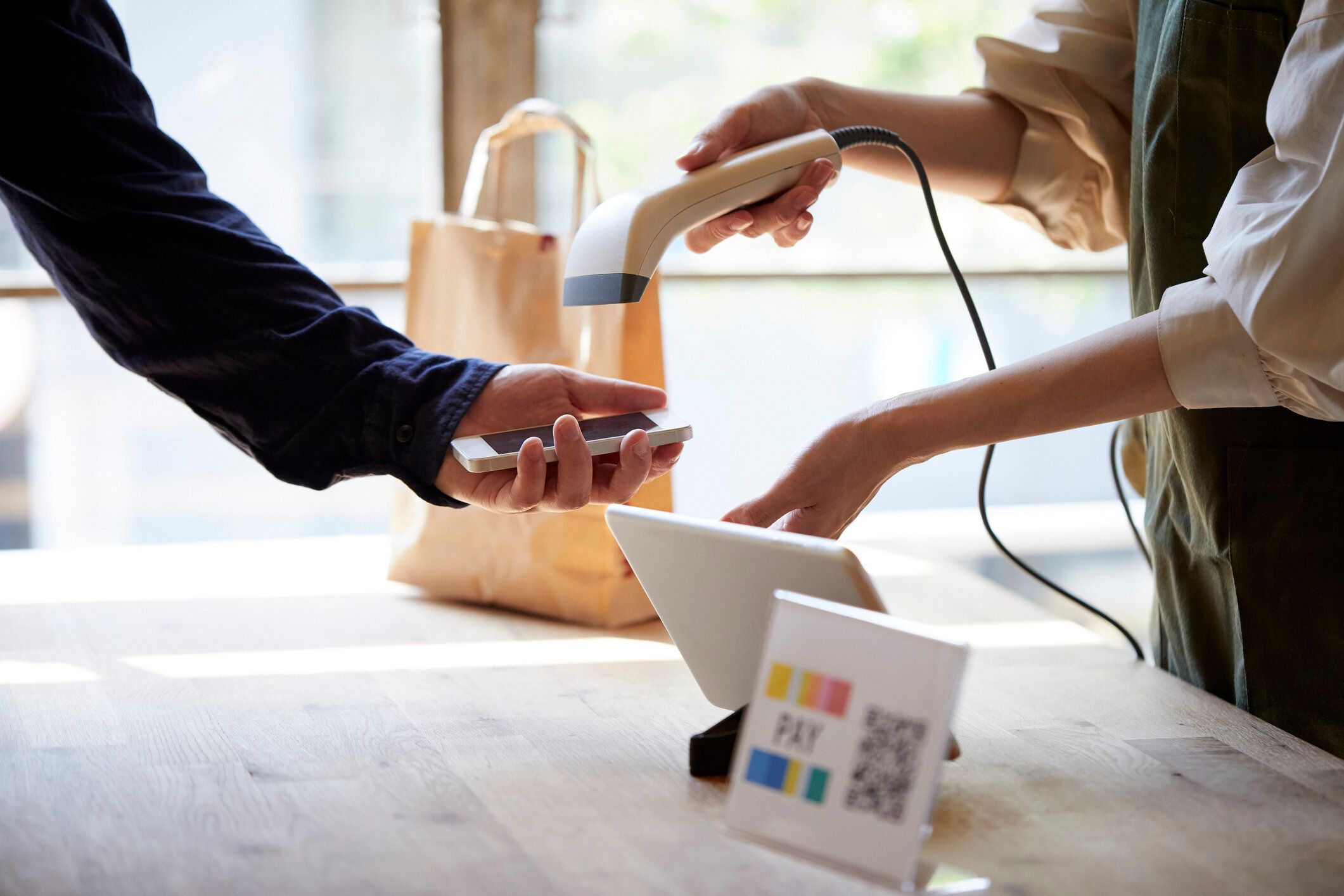 スマートフォンを使用して支払いが行われるレジで