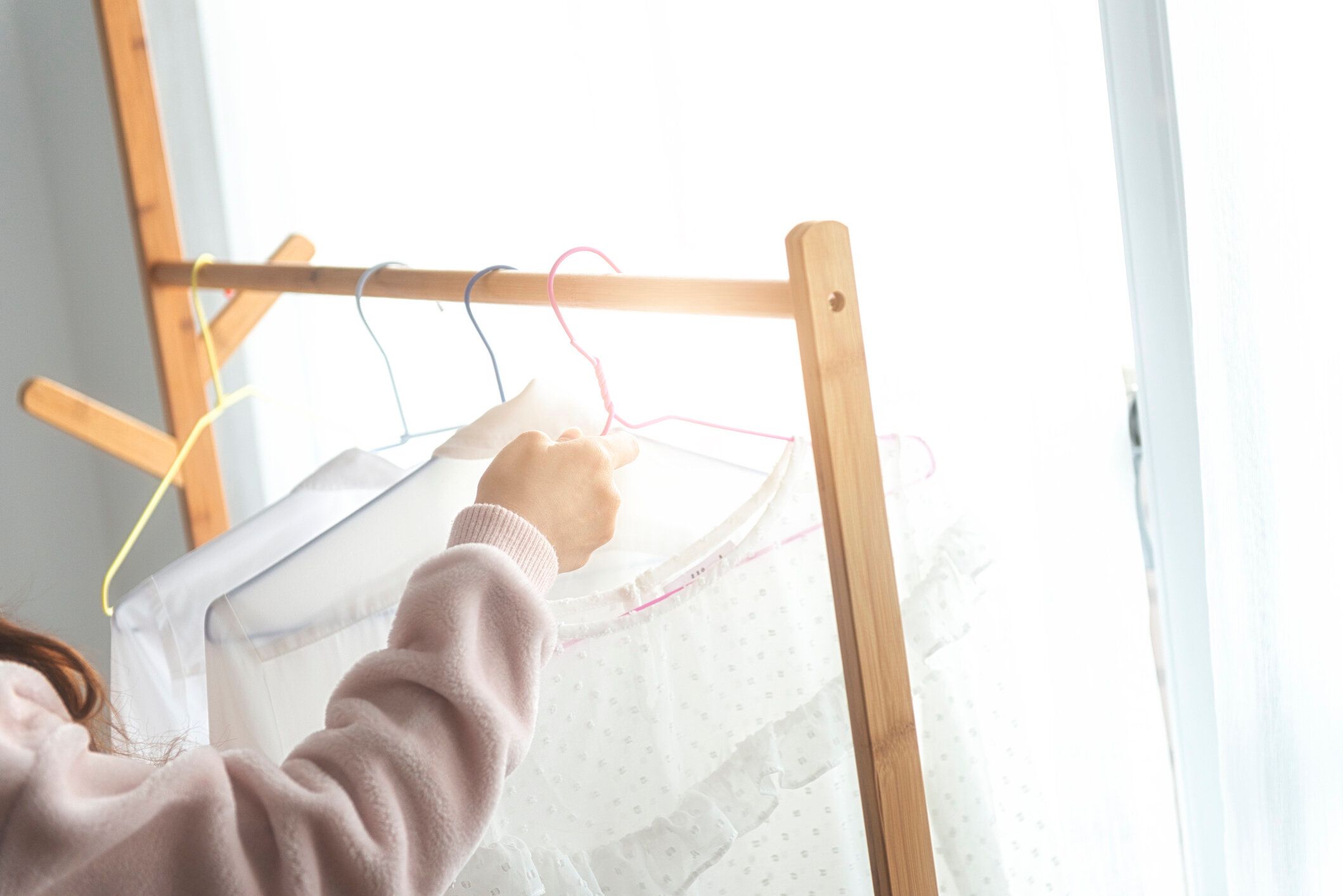 洗濯したばかりの服をラックに掛ける女性