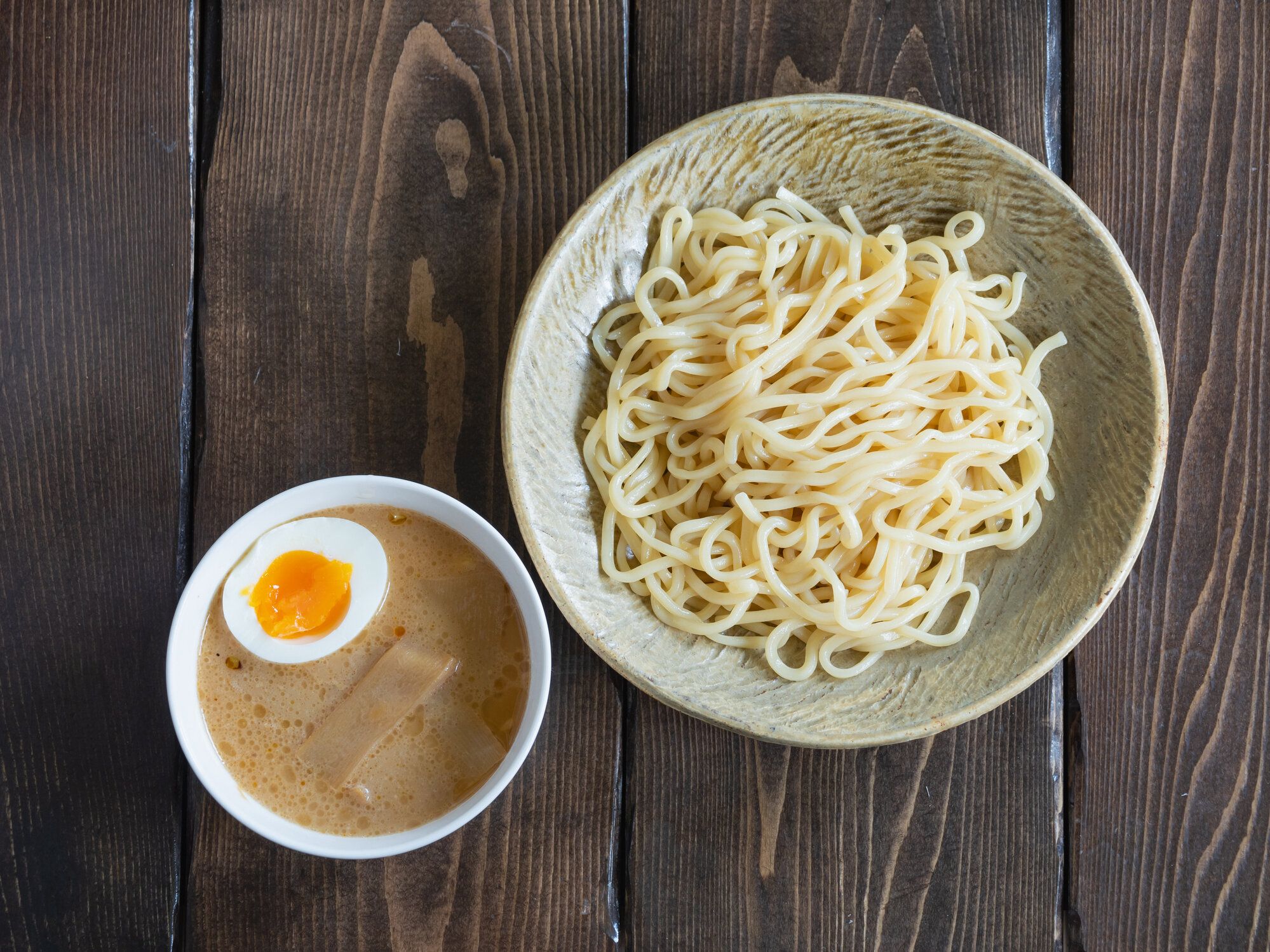 黒いボウルにつけ麺とスープ。