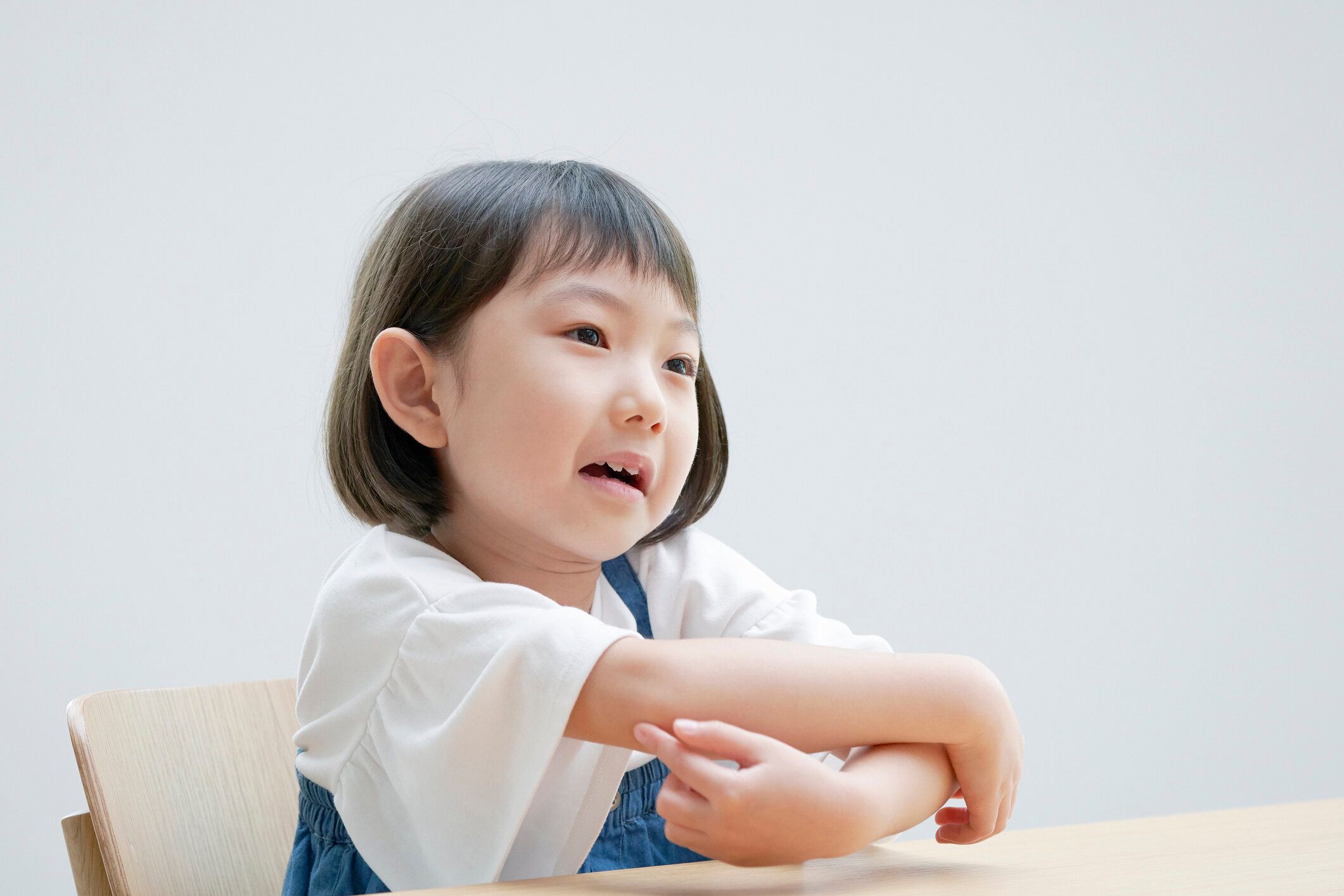椅子にかゆい感じアジアの女の子