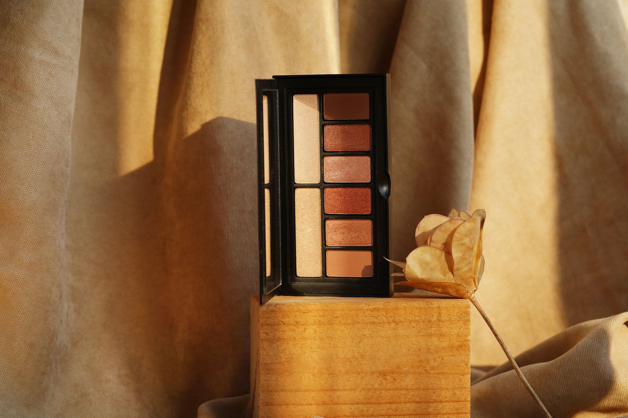 茶色の自然の背景に木材に滞在カラフルなアイシャドウパレット。目のためのファッショナブルな化粧品メイク。