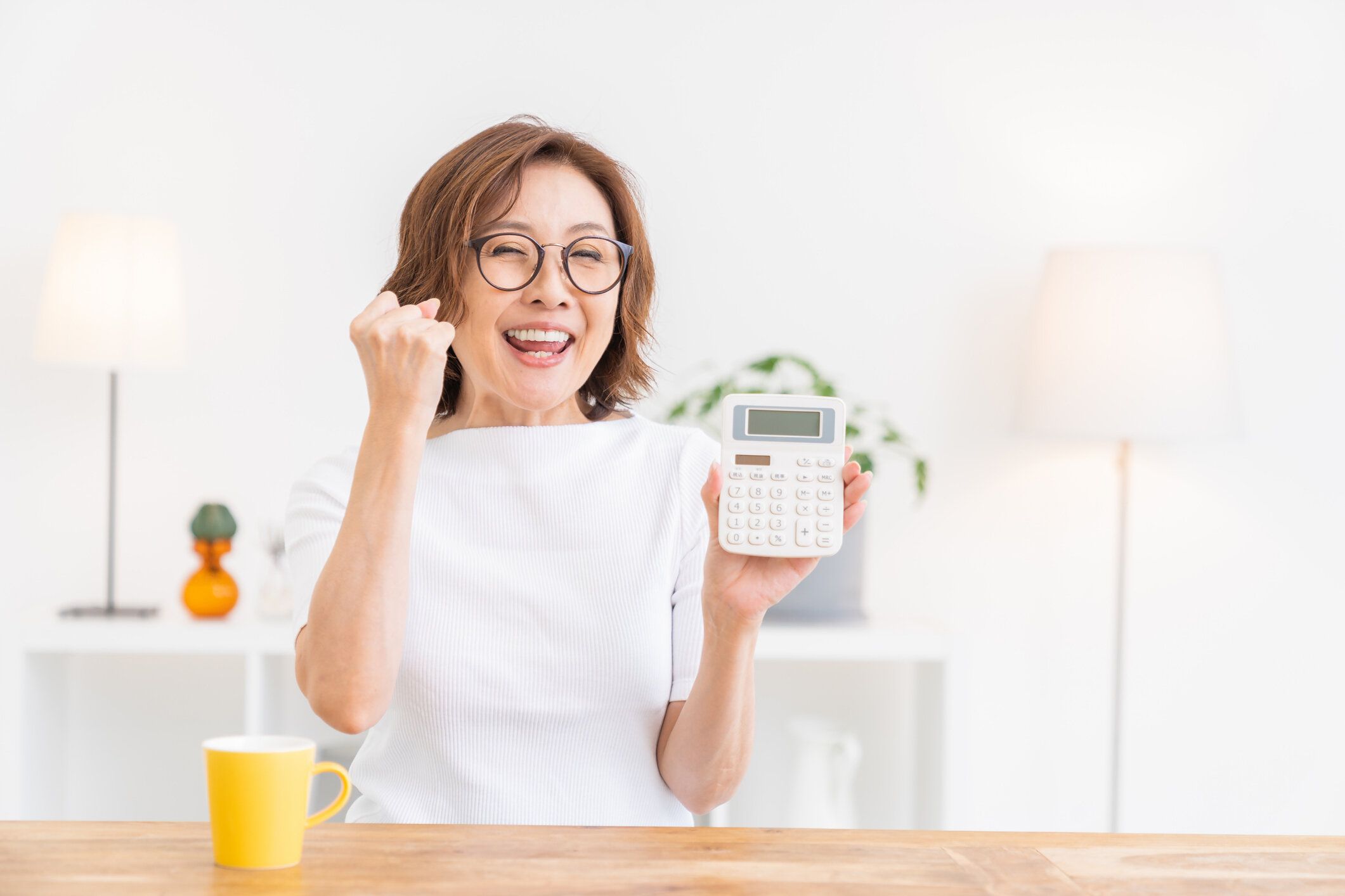 電子電卓を持つシニア年齢の女性、笑顔