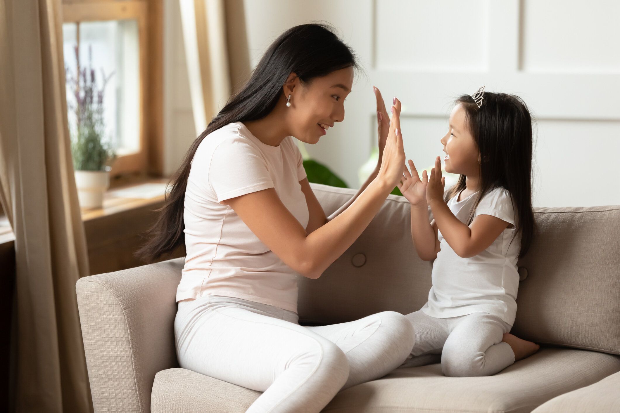 若いベトナムの母親は、小さな娘と面白いゲームに関与しています。