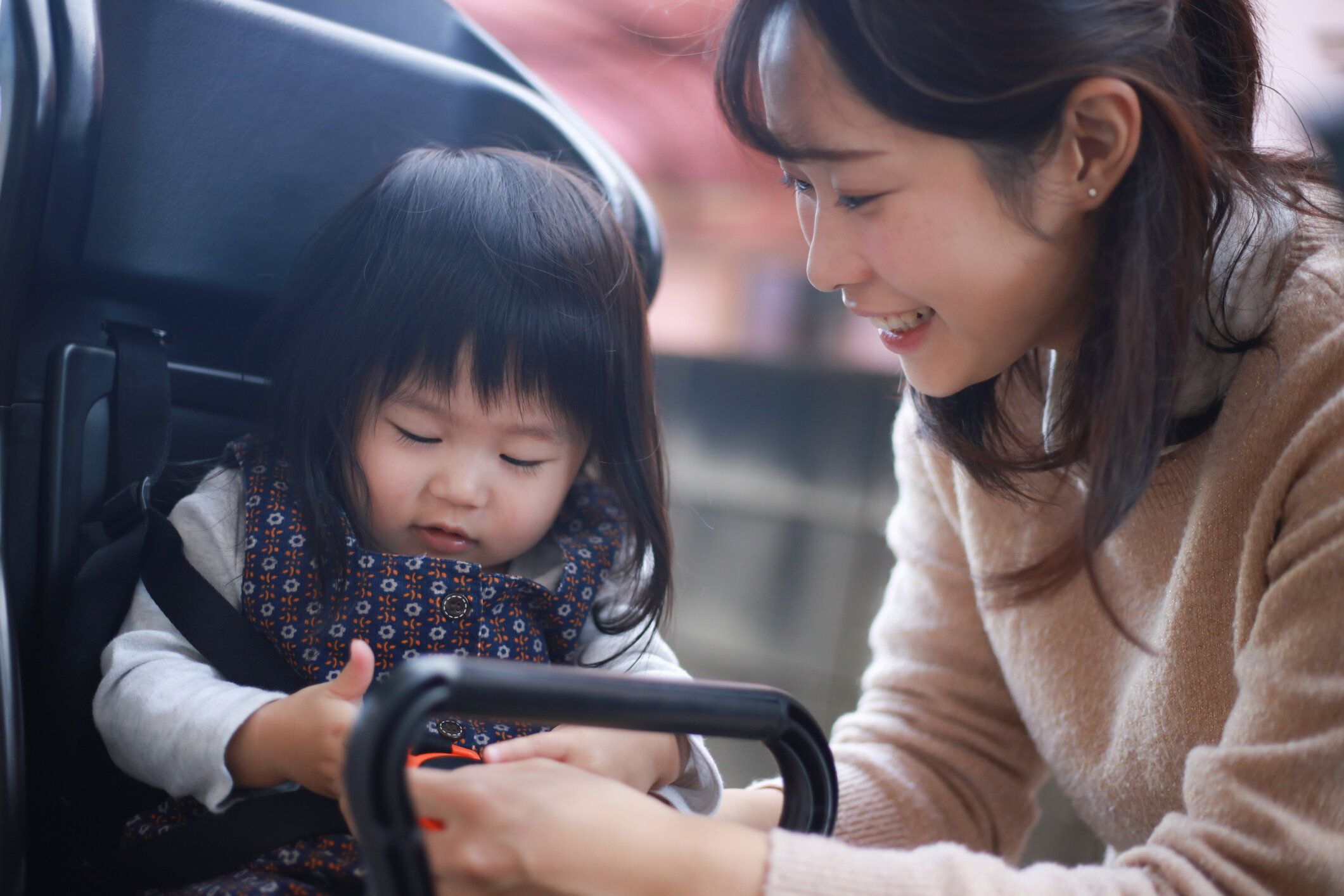 自転車に子供を運ぶ母