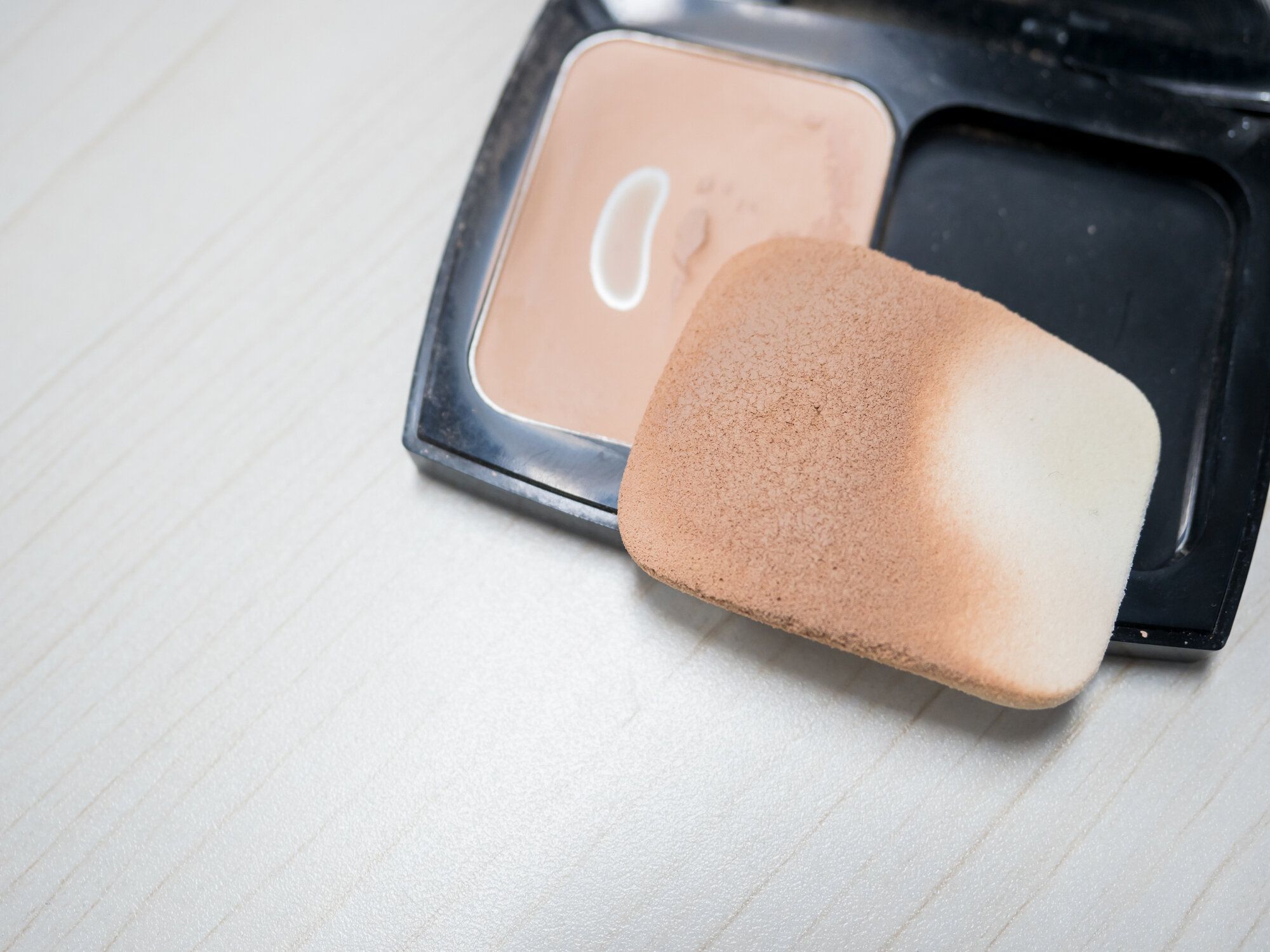 テーブルの上の古い汚れたパフとパウダー、慎重なコンセプト