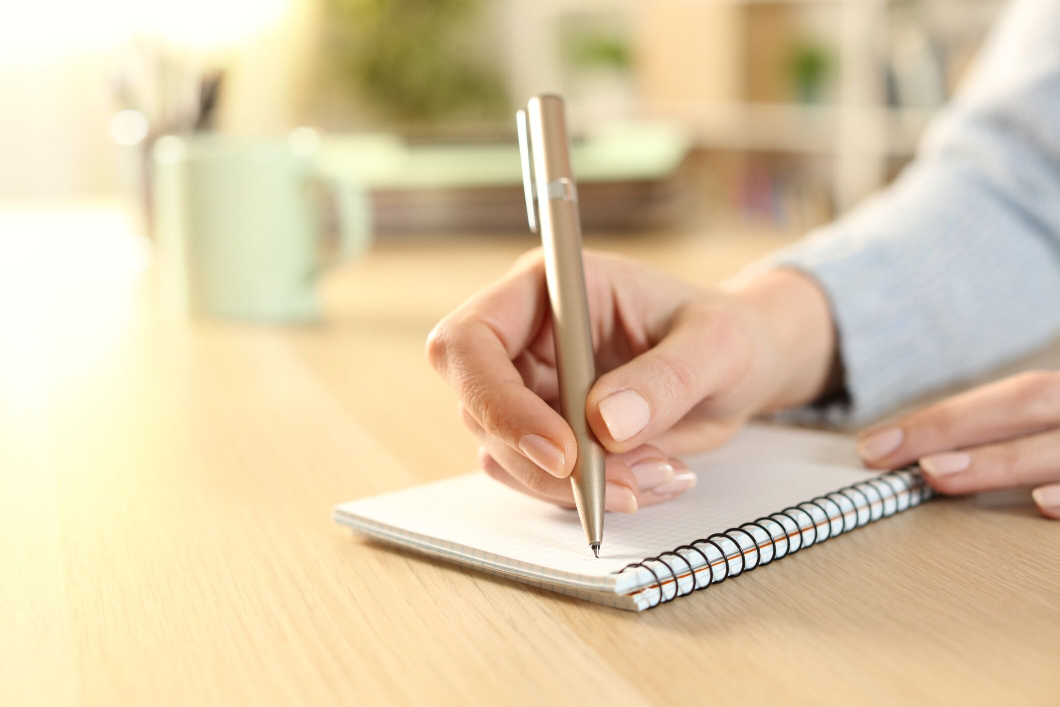 自宅でノートに書く女性の手