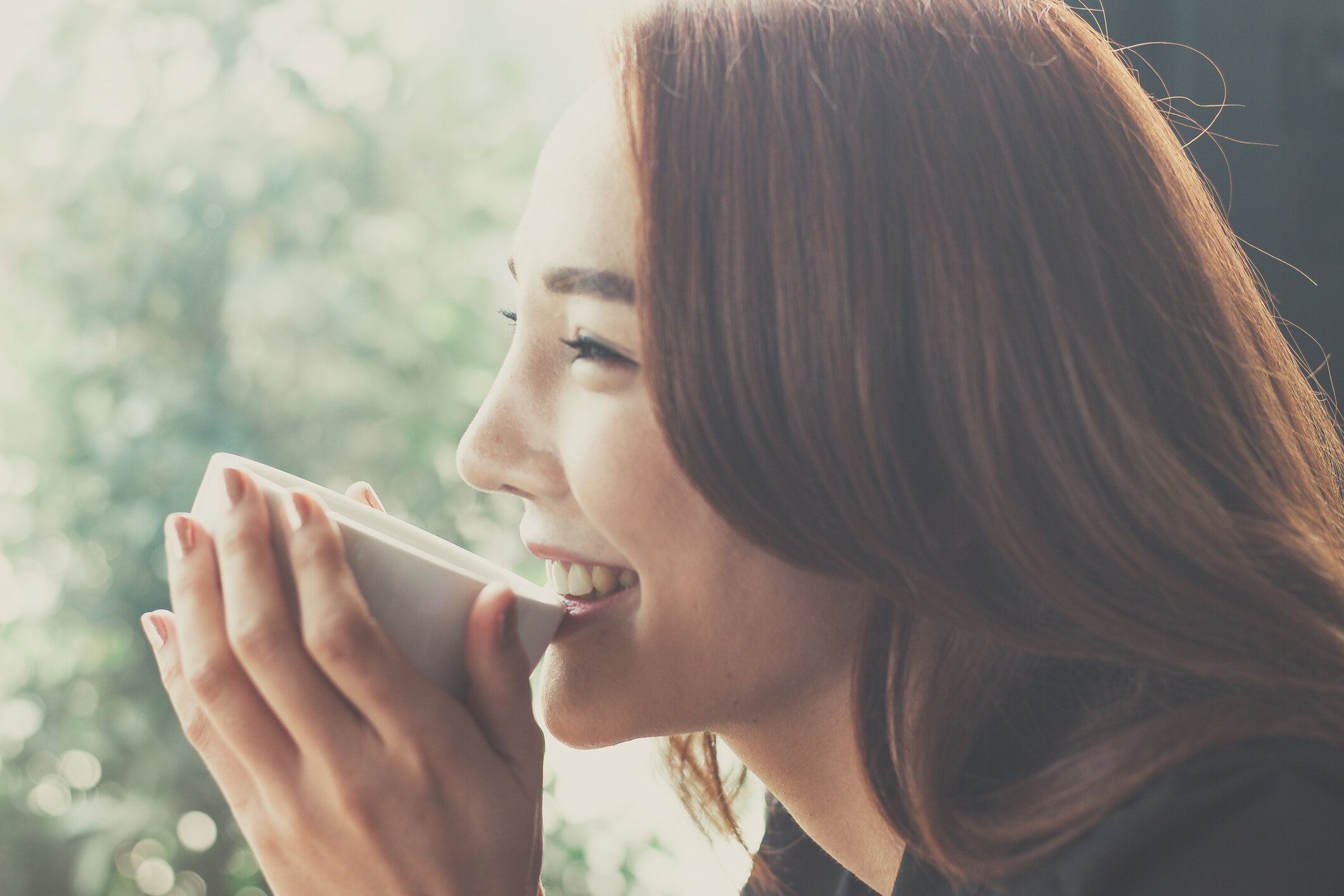 コーヒー ショップでコーヒーを飲む女性秘書は、コーヒーを飲むときに満足しています。