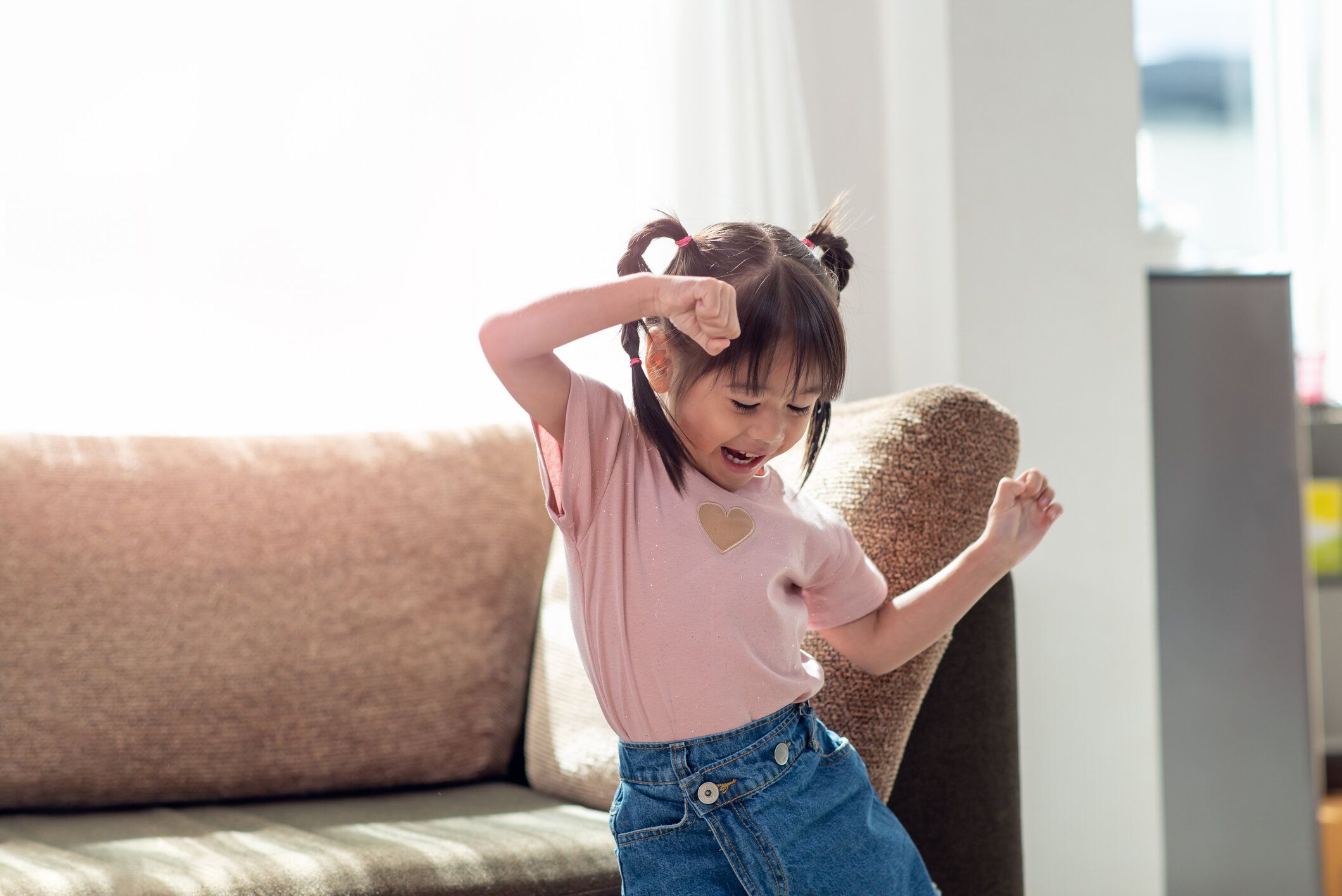 部屋で楽しいとダンスを持って幸せなアジアの子供
