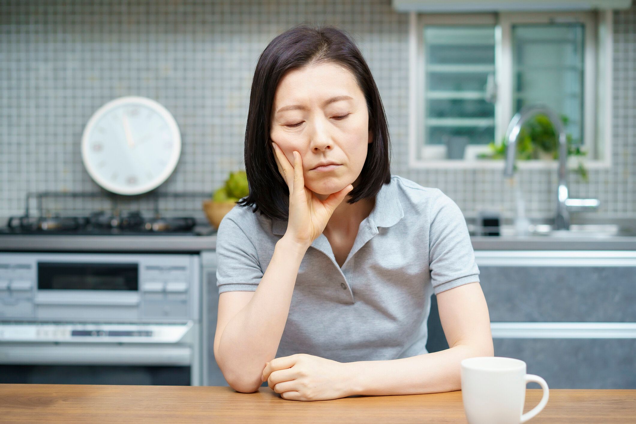 疲れた表情をした中年女性