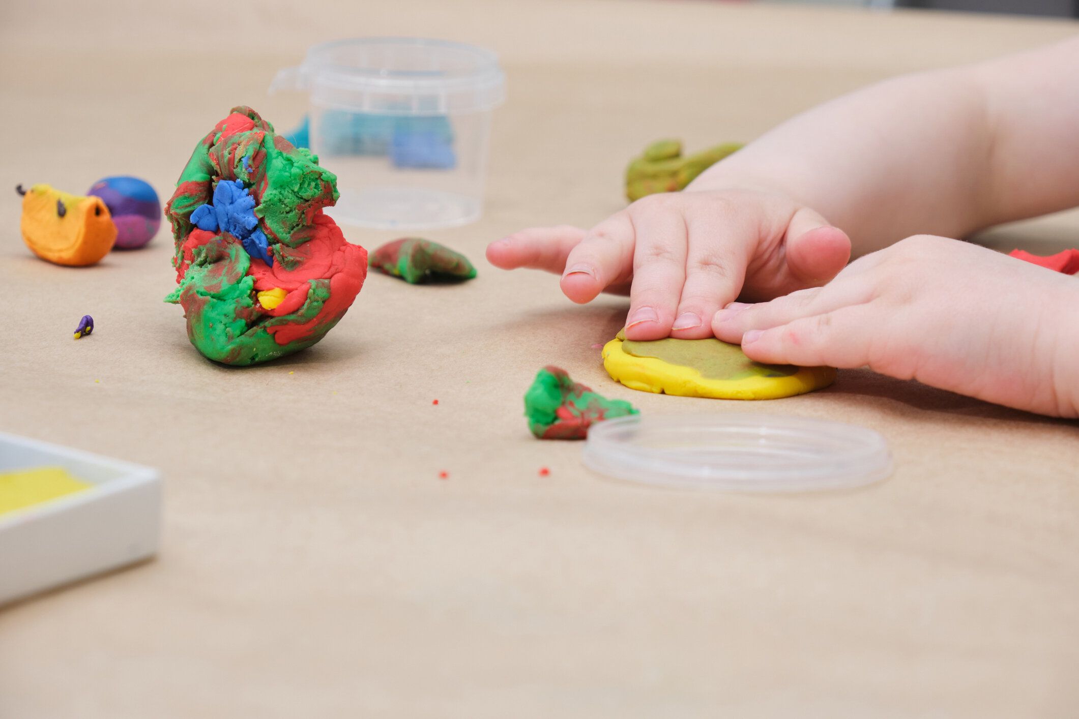 テーブルでプラスチックから彫刻子供の手、女の子はプラスチックで遊ぶ
