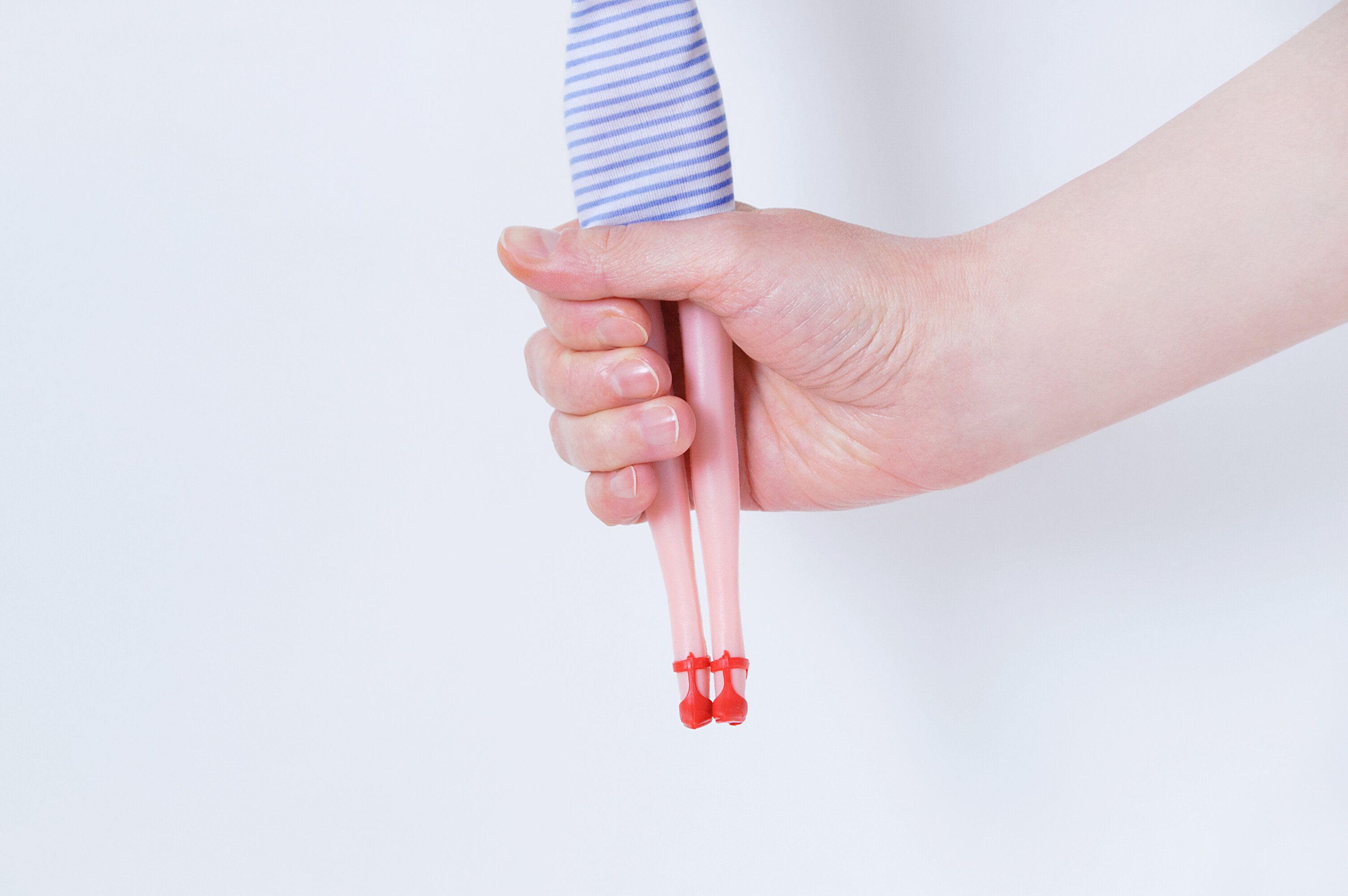 白い背景に白人の女の子のクローズアップの手におもちゃの人形。