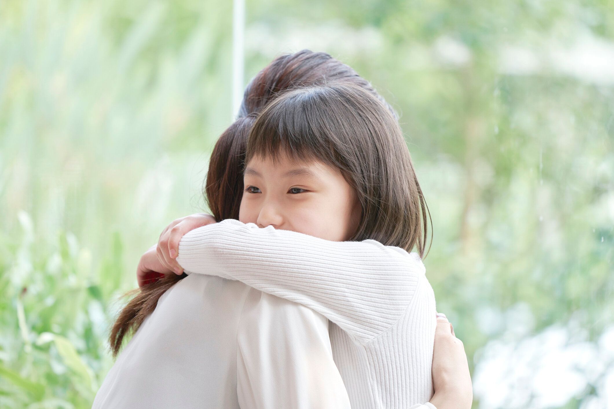 彼女の娘を抱きしめるアジアの母親