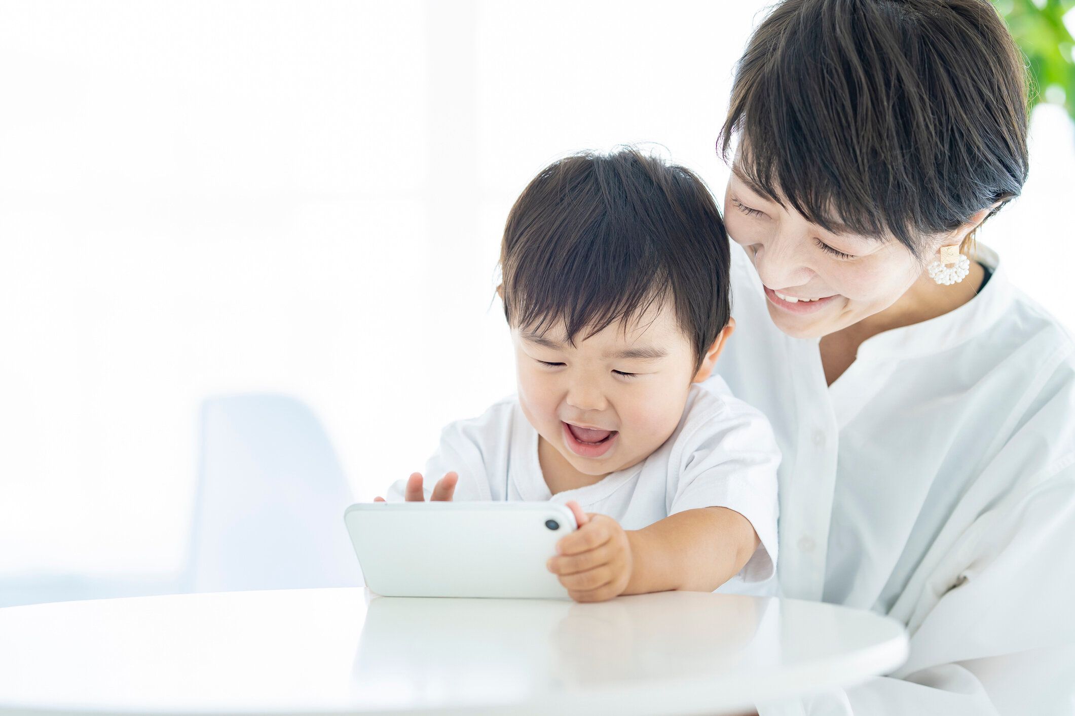 スマートフォンの画面を見て子供とママ