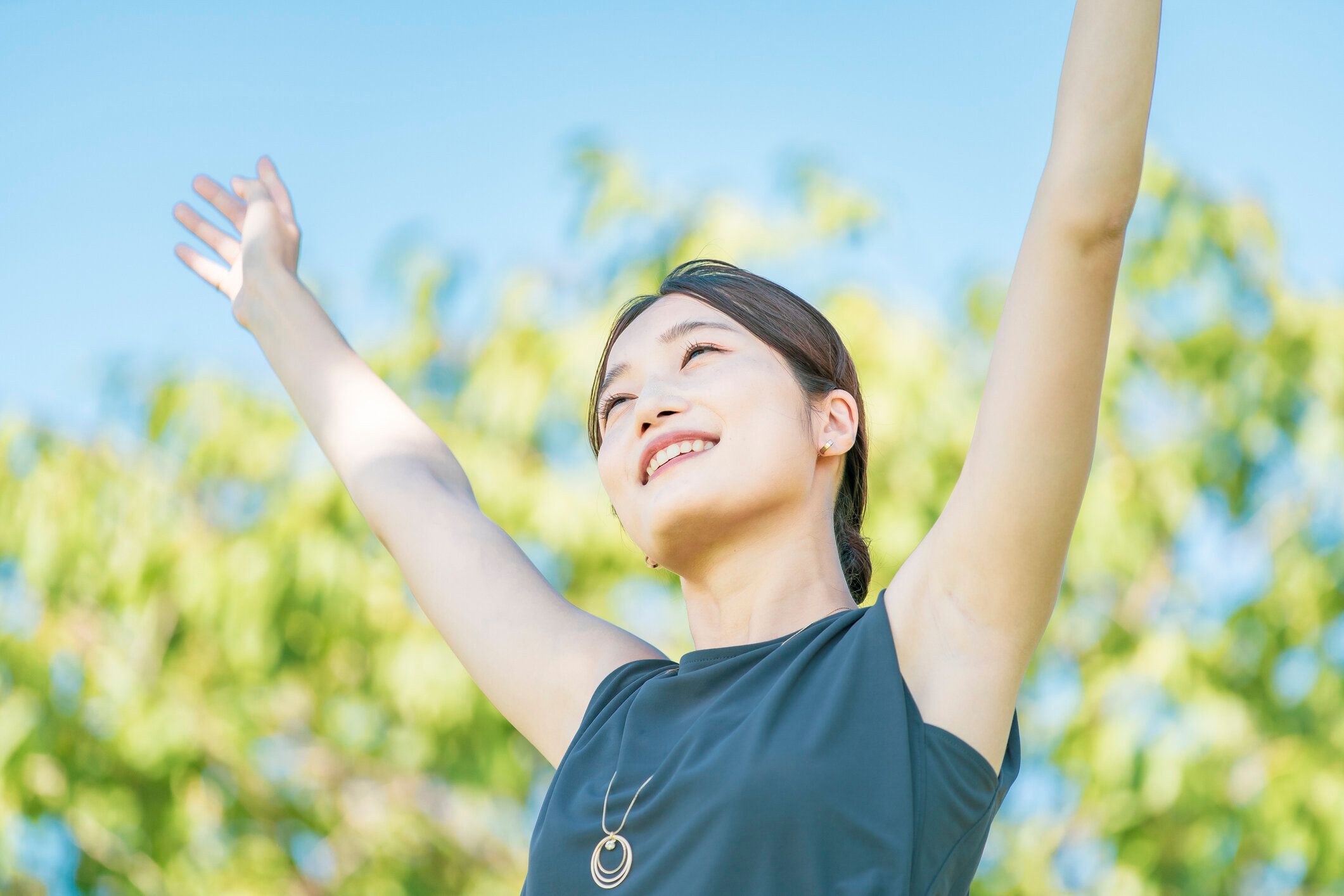 緑の中でリラックスした若い女性