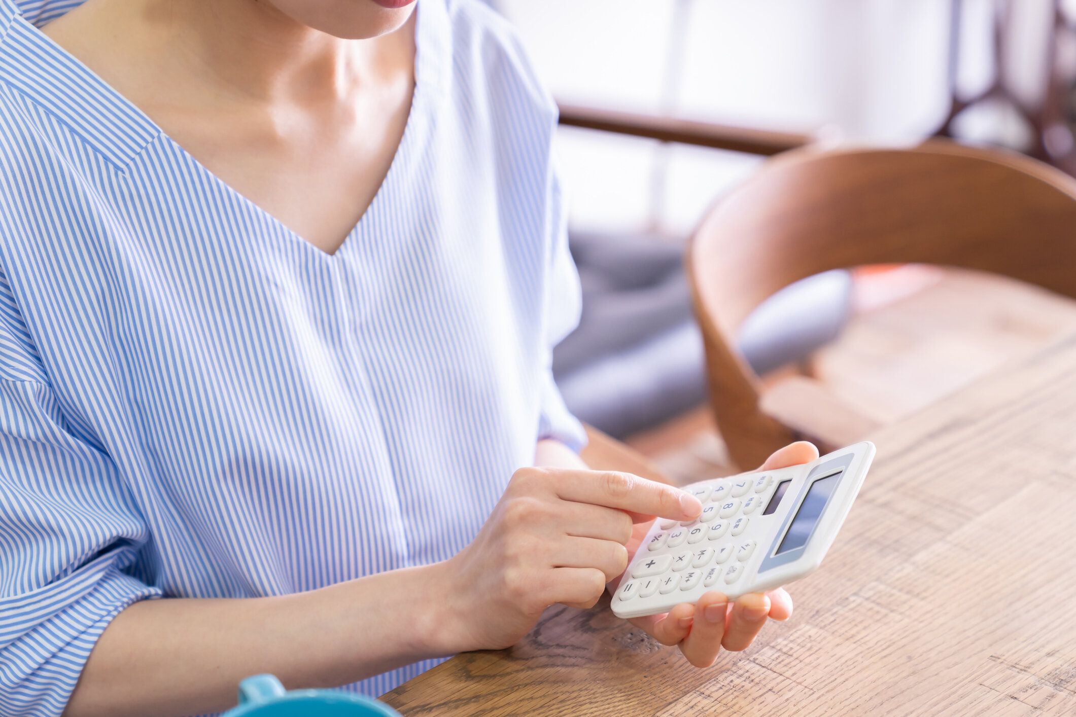 女性の手と電子計算機