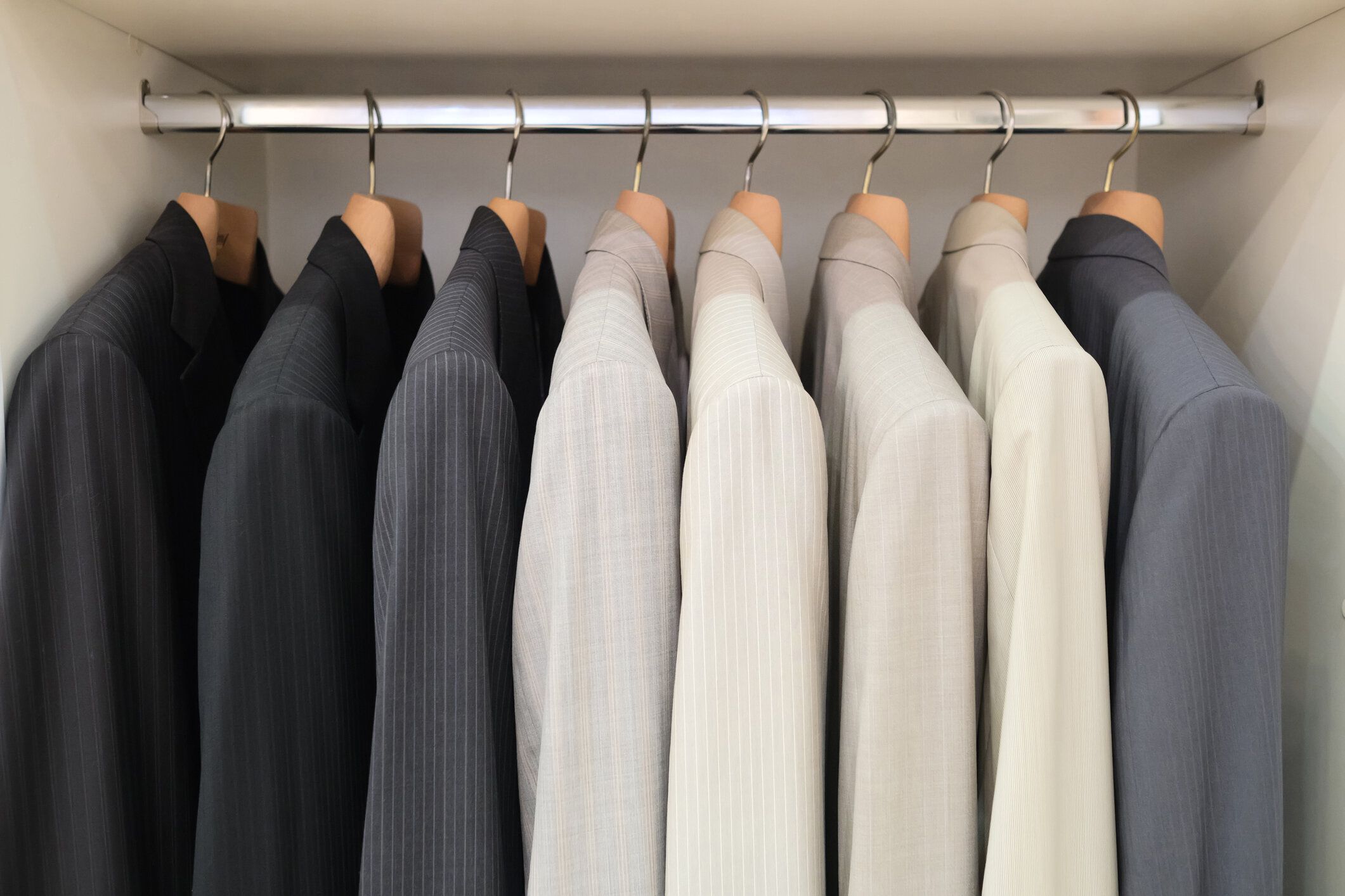 ラックに掛かっているスタイリッシュな服を着たワードローブ。