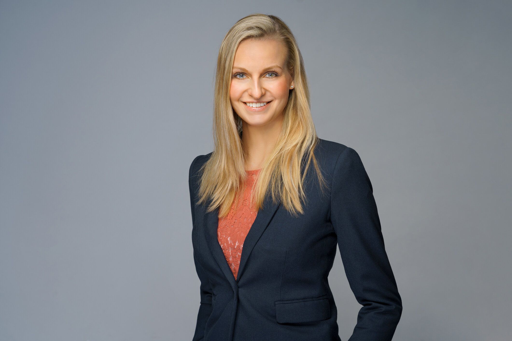 壁に笑ってゴージャスなブロンドのビジネスウーマン