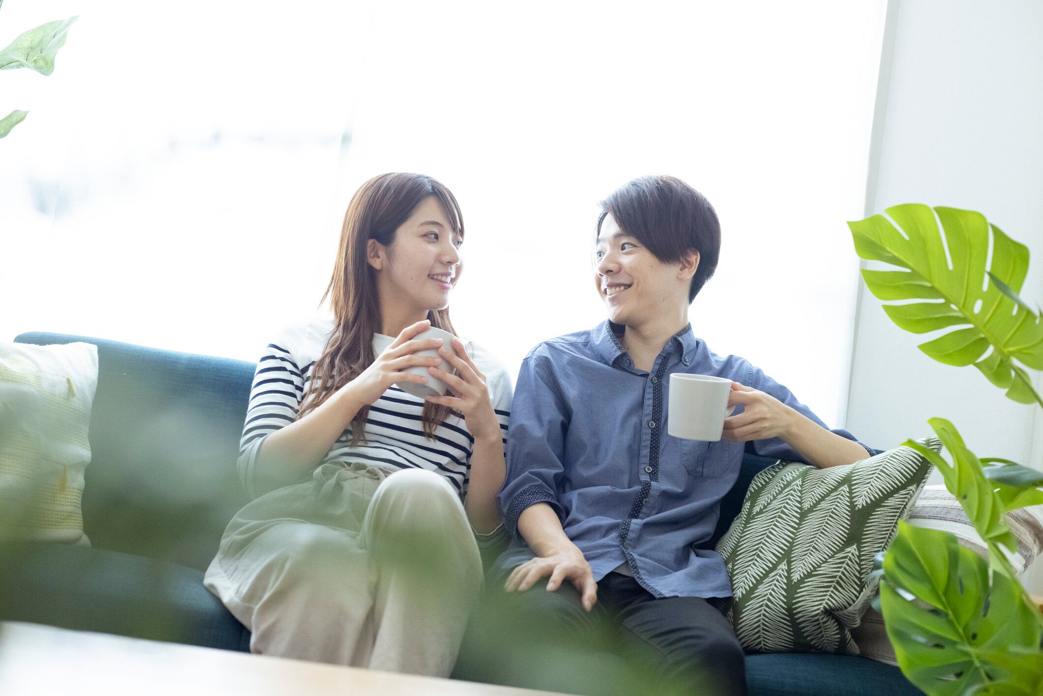 居間でリラックスした、見栄えの良い日本の男女