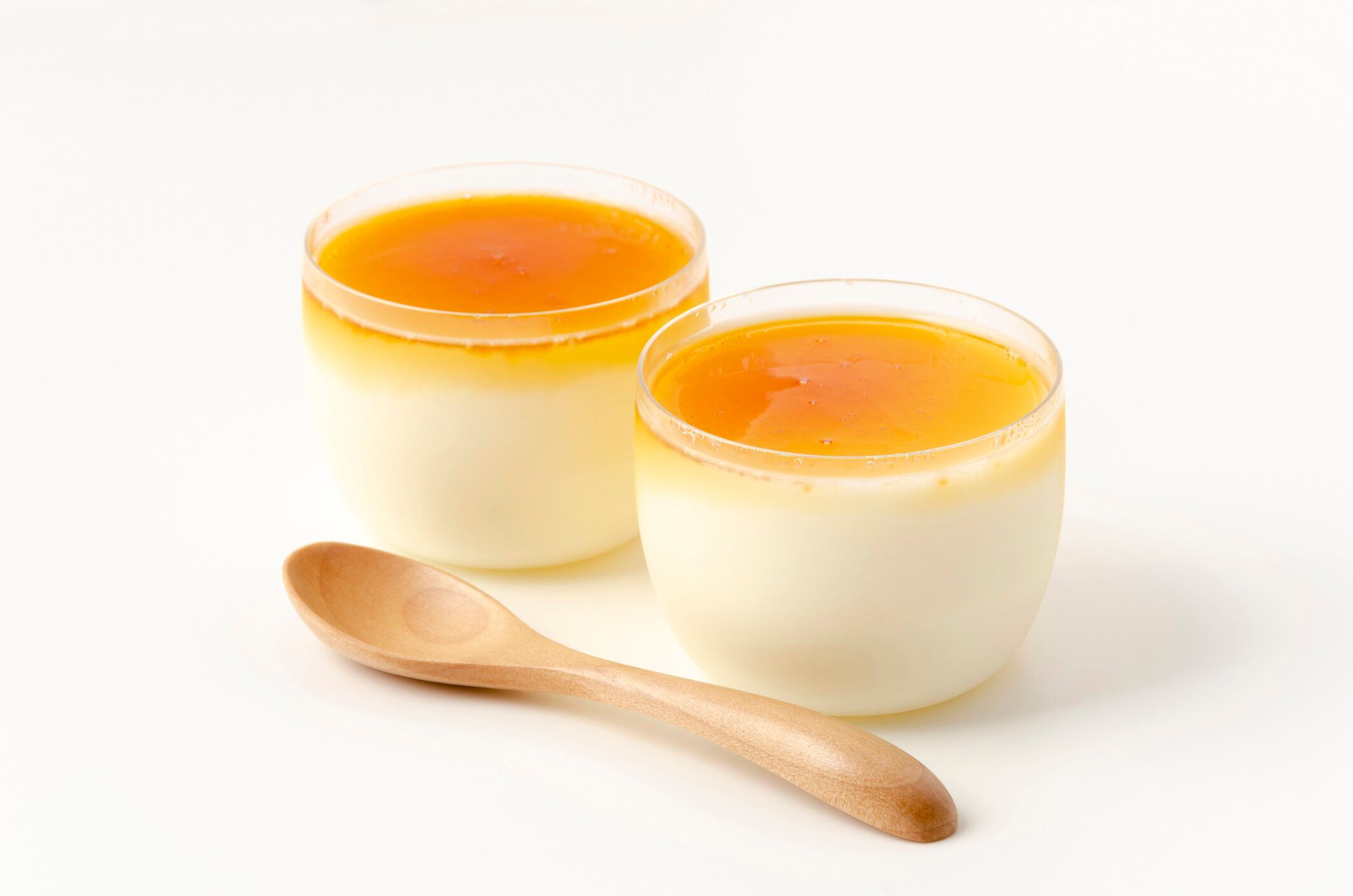 白い背景にプリンカップで手作りのキャラメルミルクプディング