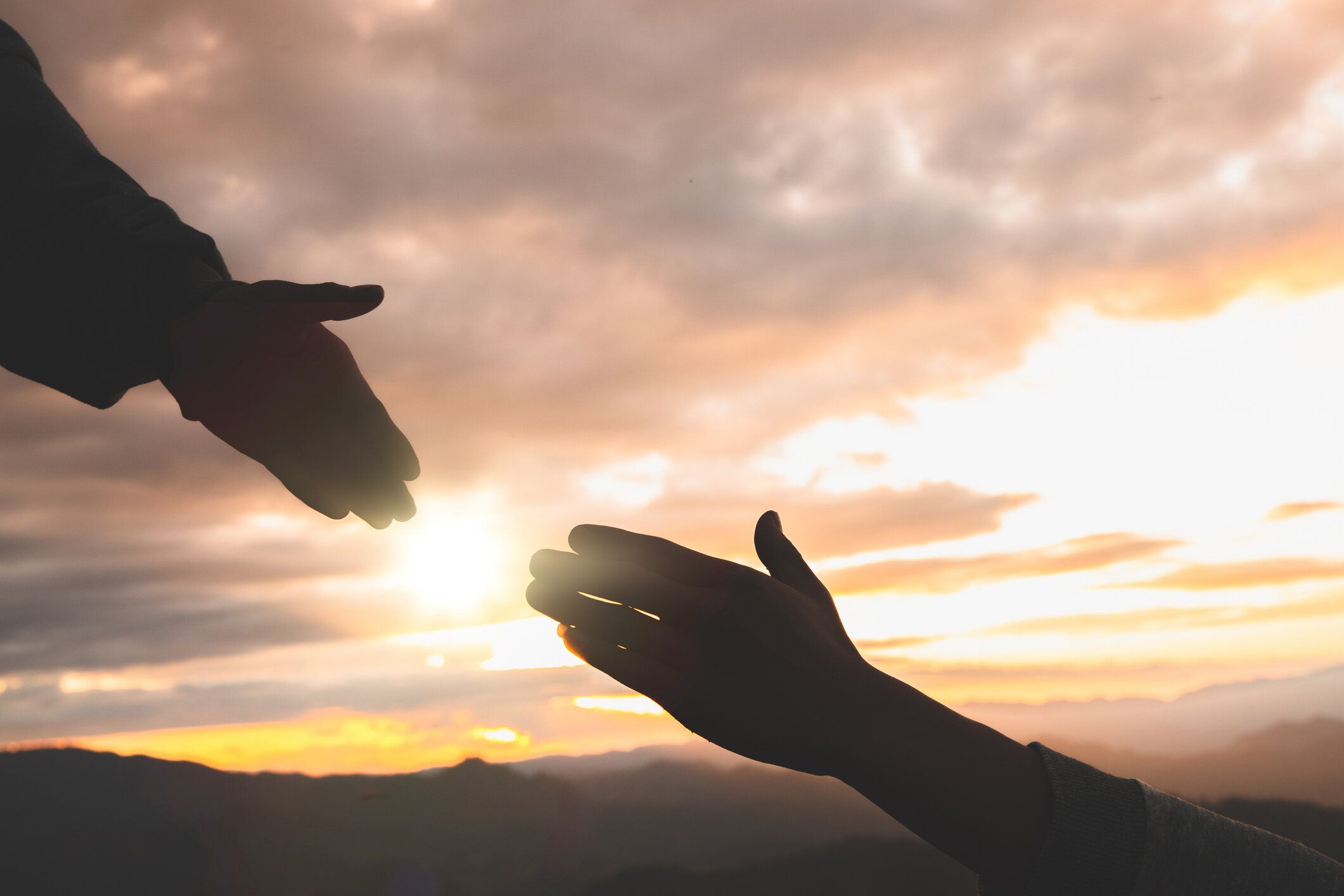 手を伸ばし、救いの手を差し伸べ、お互いに希望と支え合い、手を助けるシルエット。