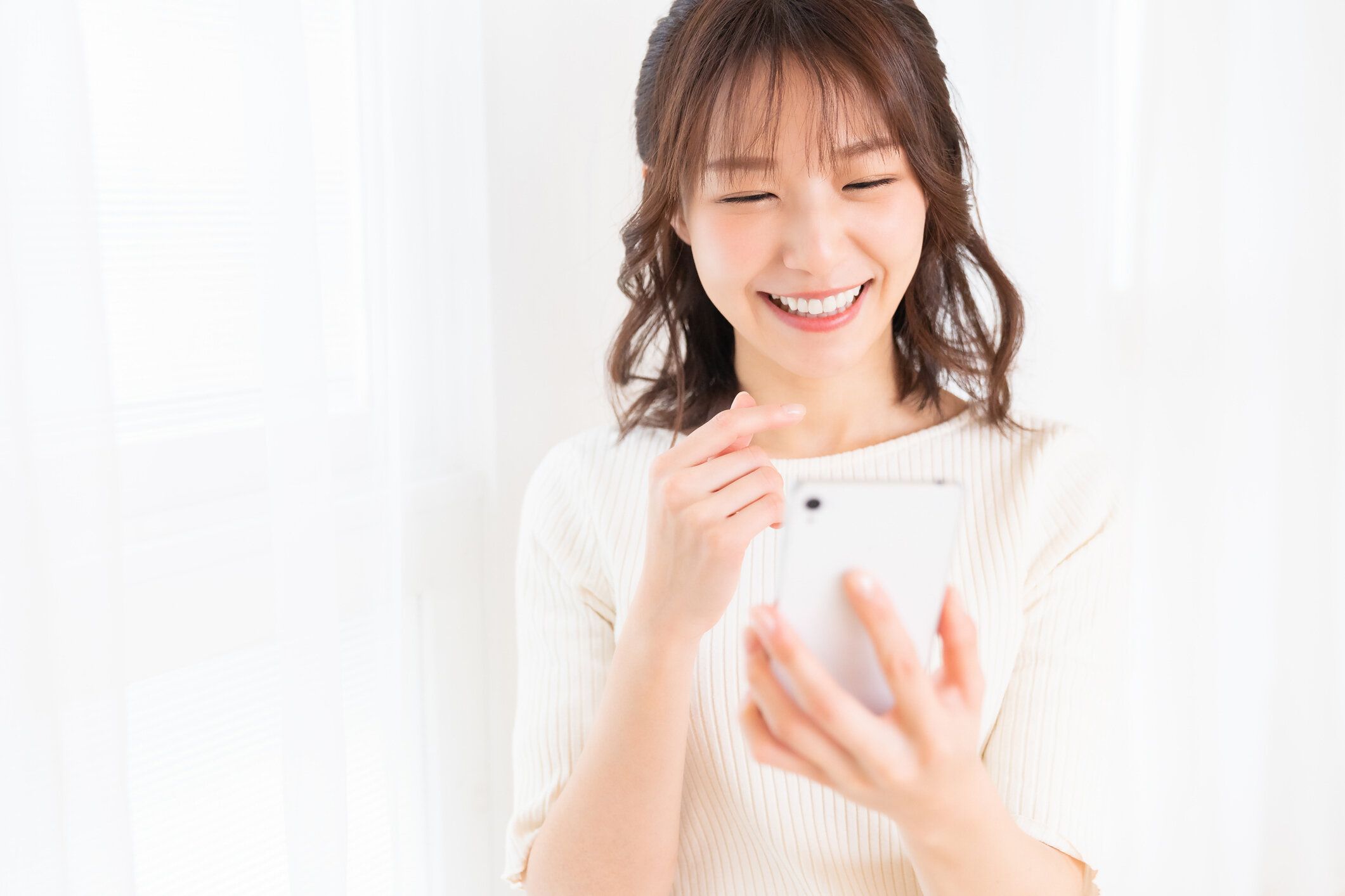 スマートフォンを使用して魅力的なアジアの女性