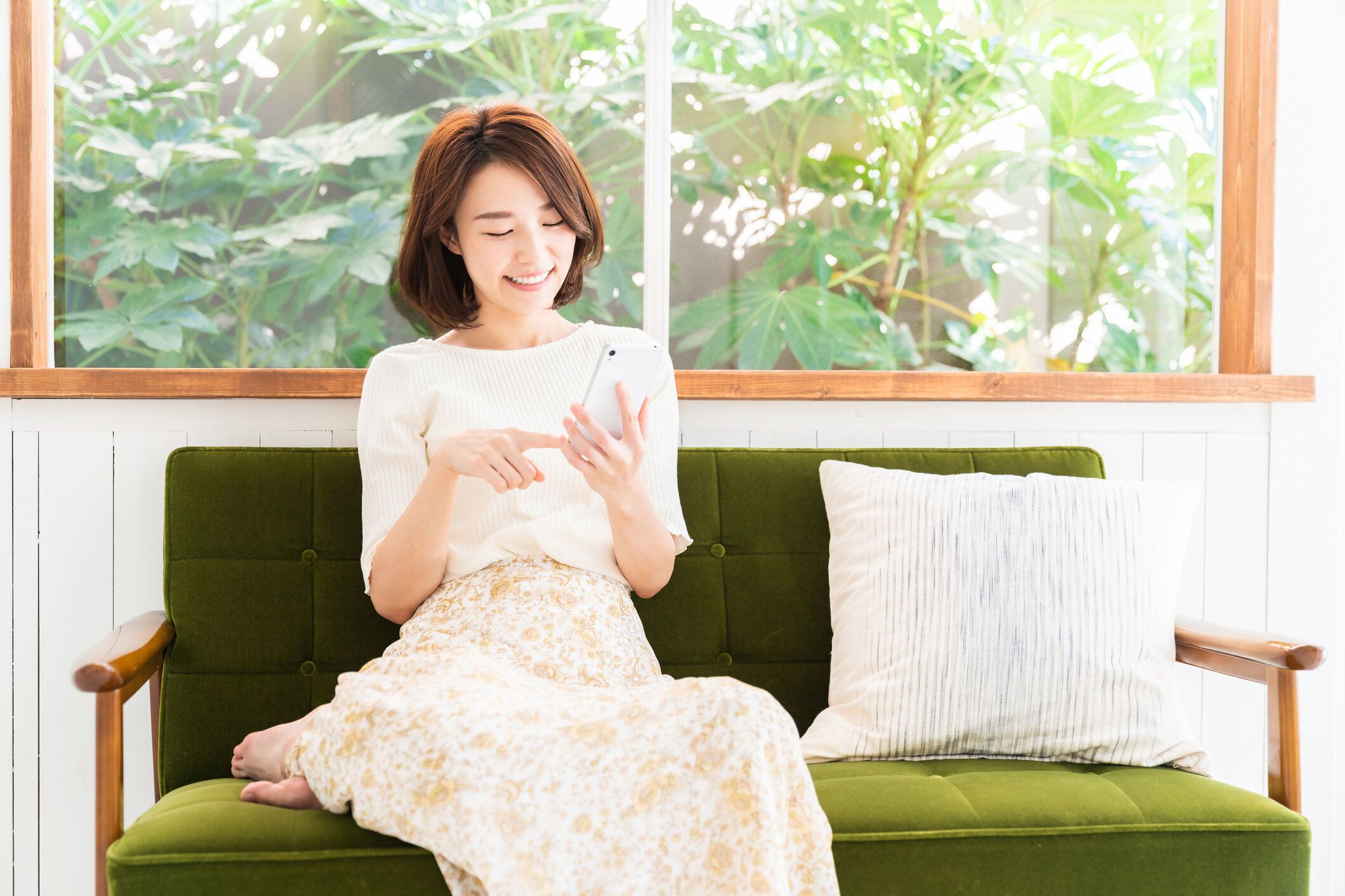 スマートフォンを見て魅力的なアジアの女性、