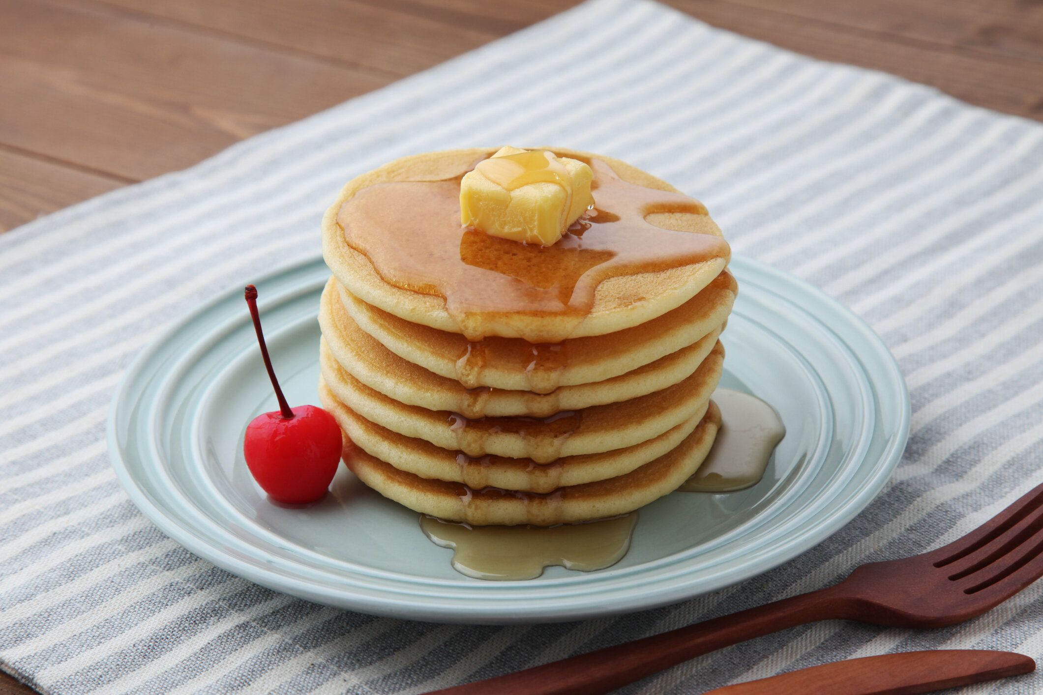 テーブルの上の皿の上に分離されたメープルシロップとパンケーキケーキ