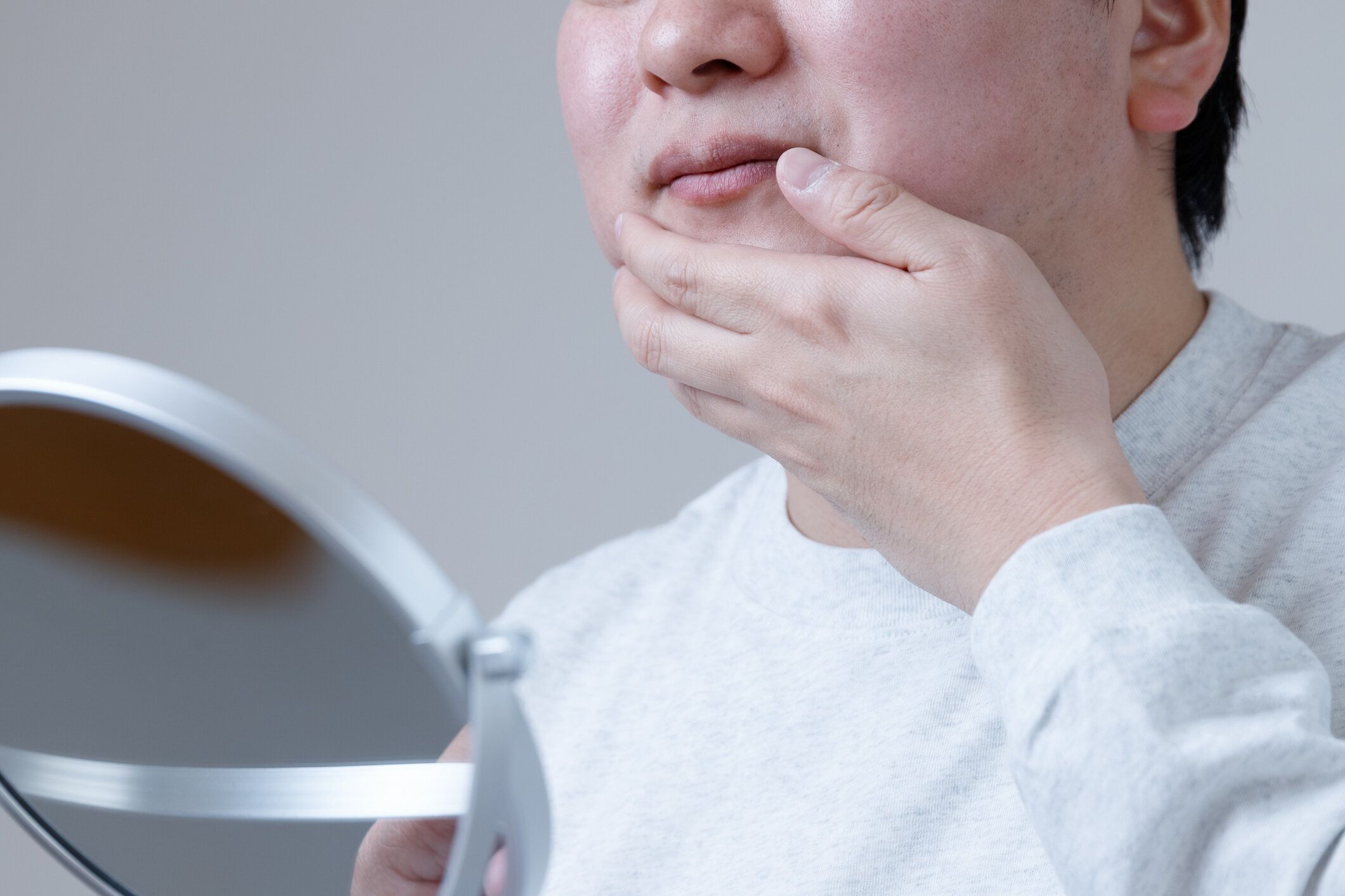 アジア人男性は、スキンケアや髭剃りの後に肌に触れることで悩んでいます。これは男性のスキンケアのイメージです