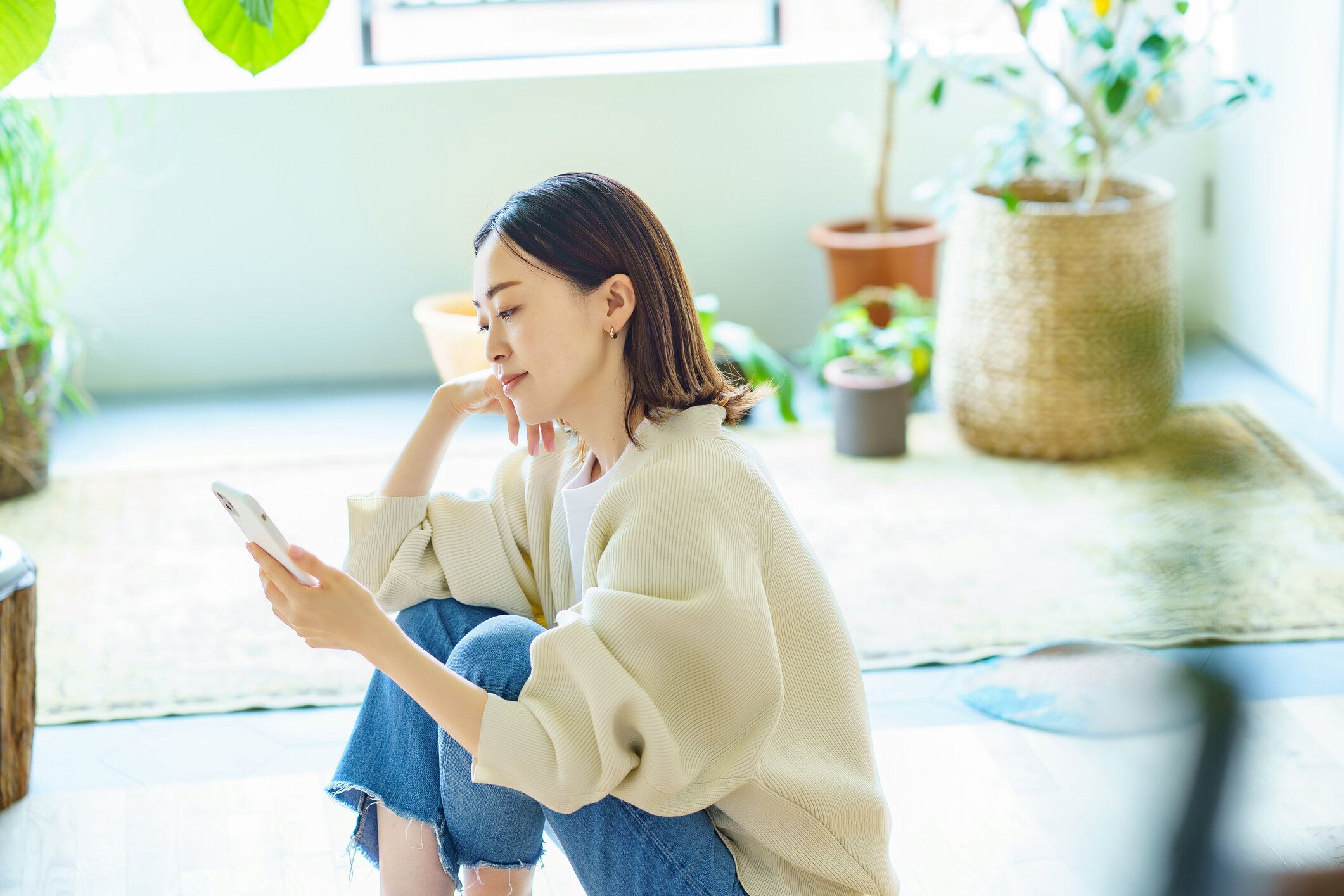 部屋でスマホを持っている女性