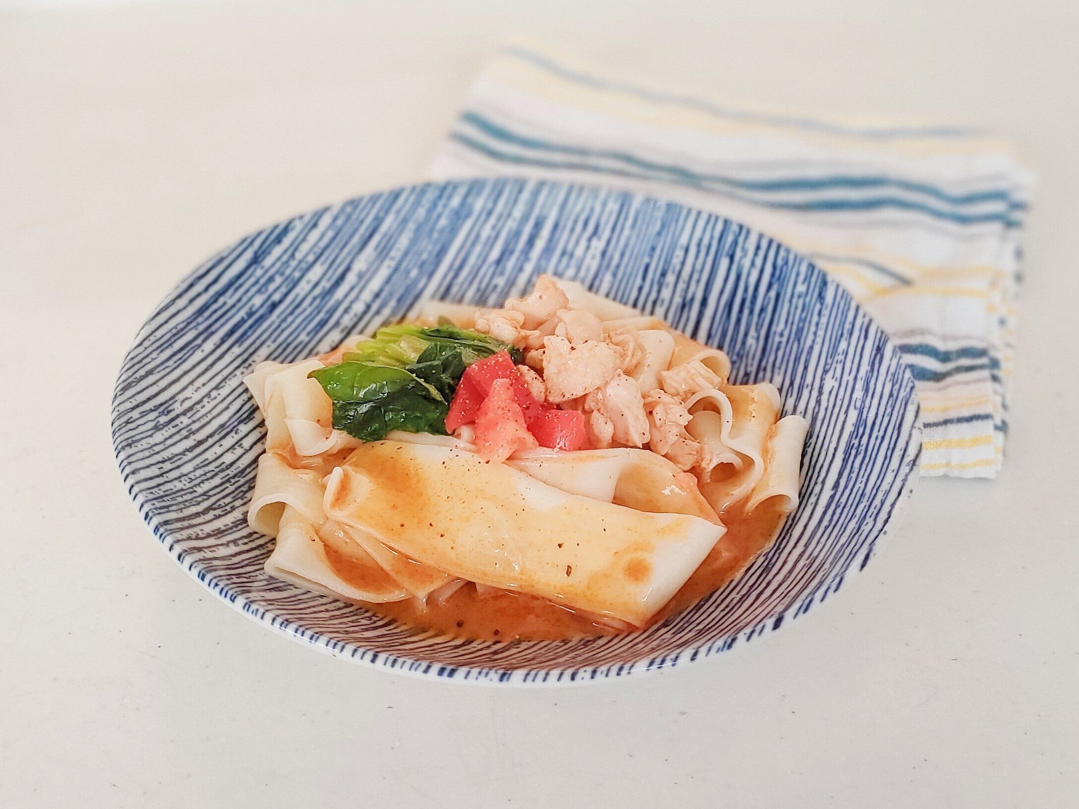 ほうれん草やトマトお肉などを盛り付けたビャンビャン麺