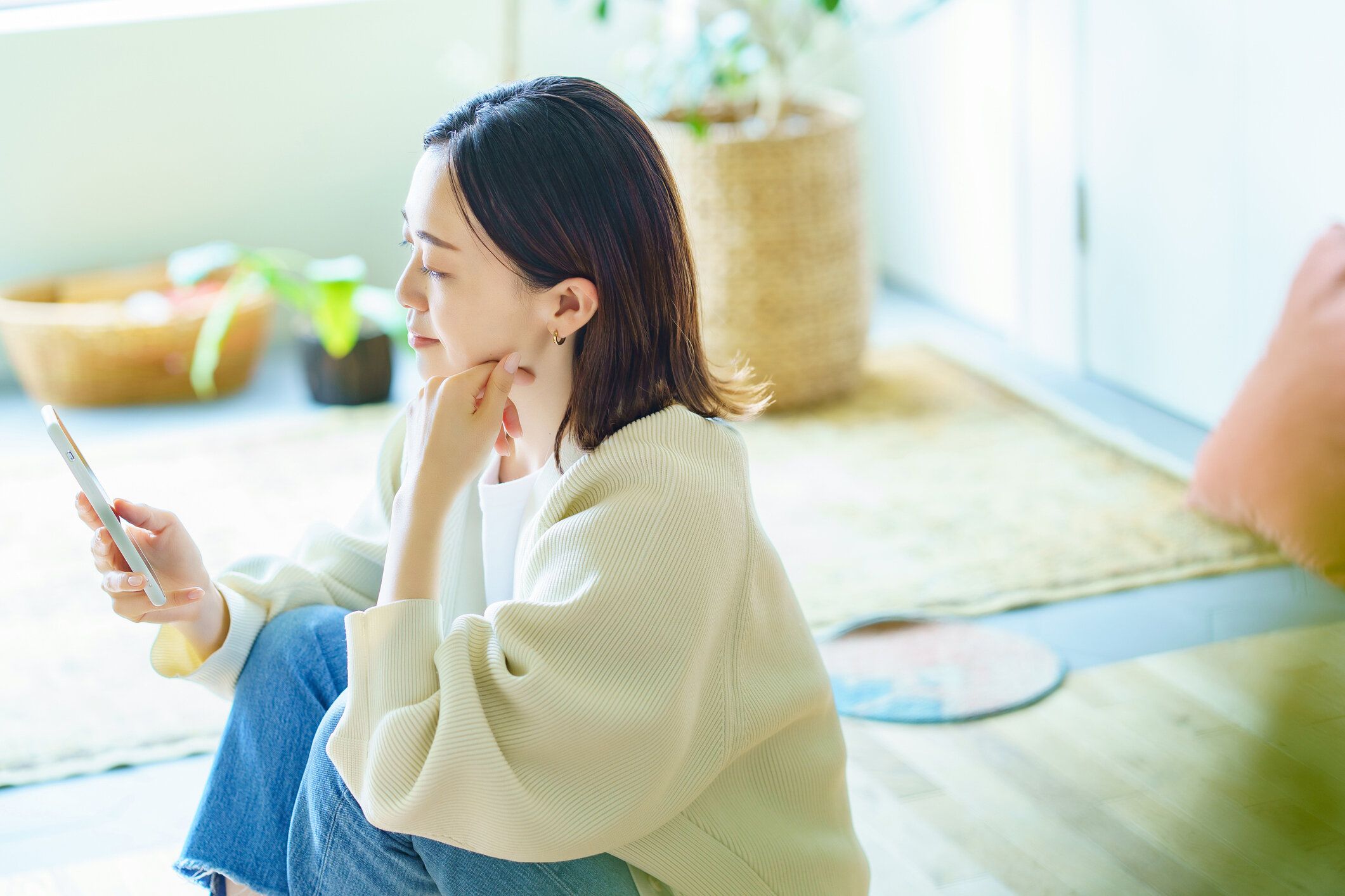 部屋でスマホを持っている女性