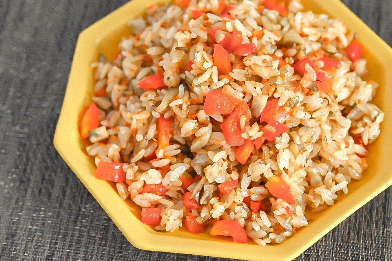 黄色い皿に盛られたまいたけとパプリカのピラフ