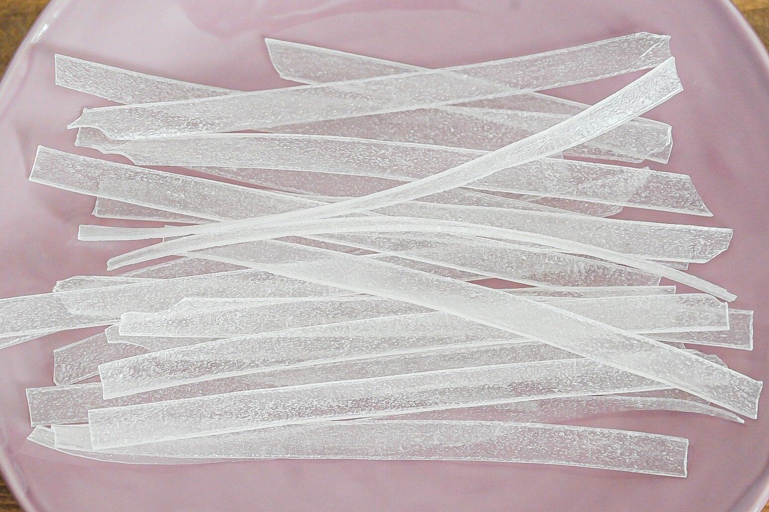 ピンクの皿に入った乾麺のタンミョン