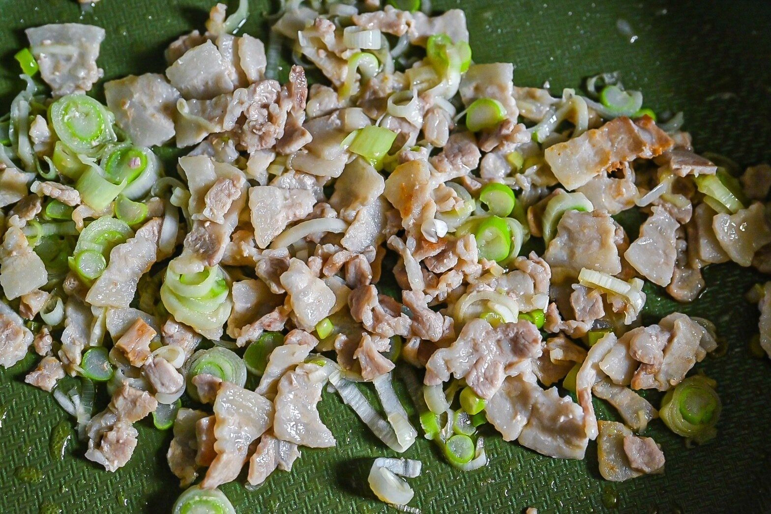 フライパンに入った炒めた豚バラ肉と長ねぎ