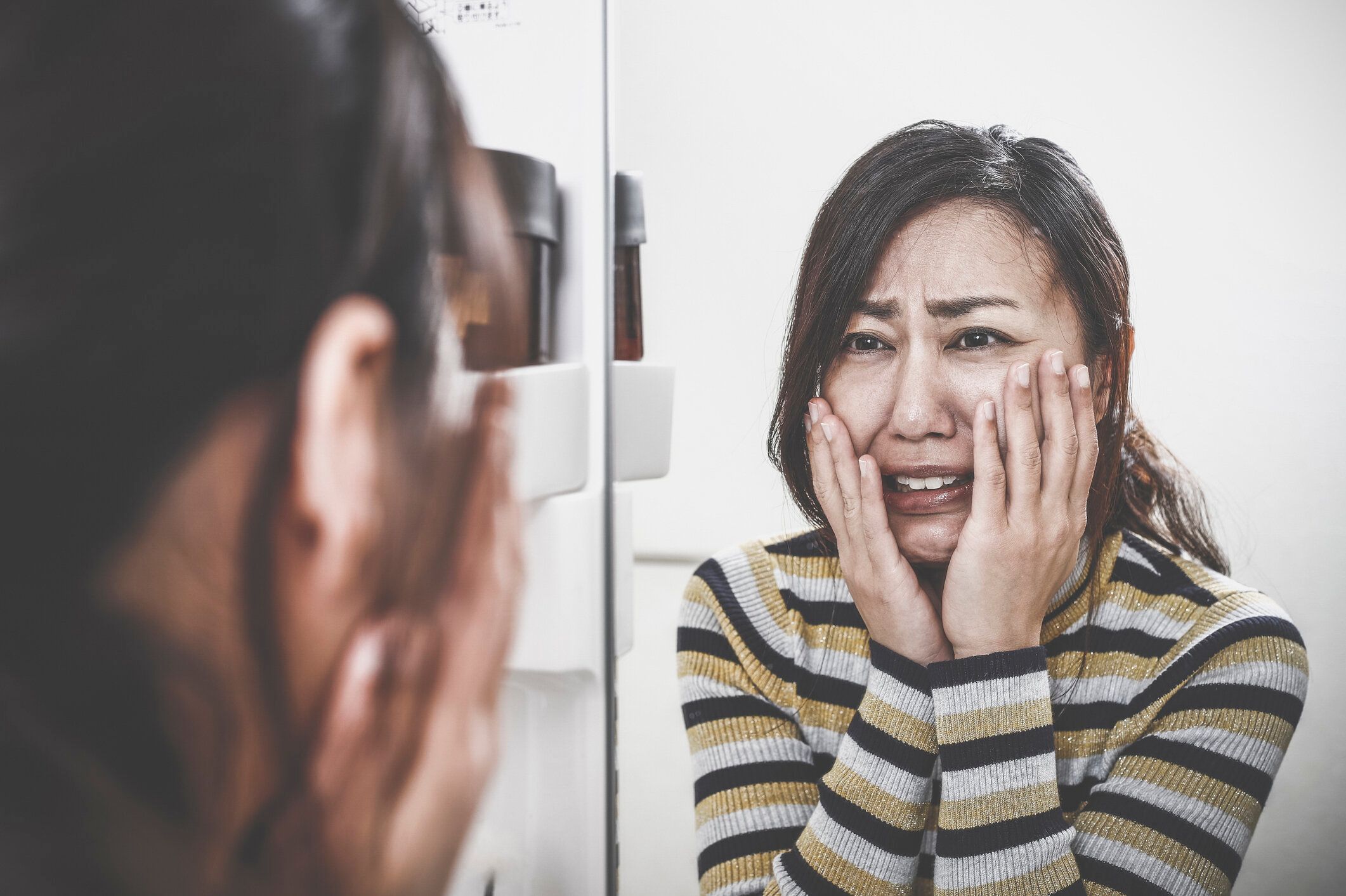鏡を見てショックを受けた女性
