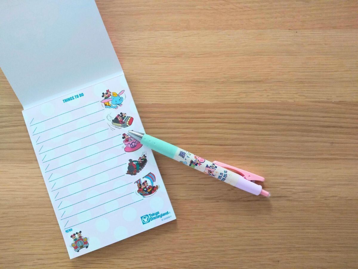 テーブルの上に置かれたメモ帳とボールペン