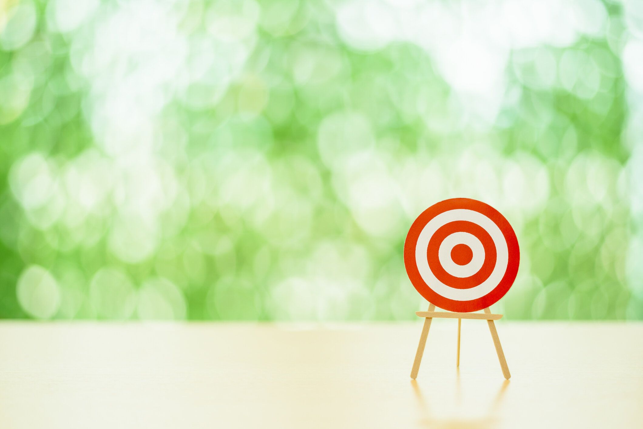 テーブルの上にダーツや赤いブルズアイがない空白の円形ターゲット。ターゲットは、企業の成功や、ターゲットオーディエンス、意図されたビジネス目標などの他の手段の比喩として利用�