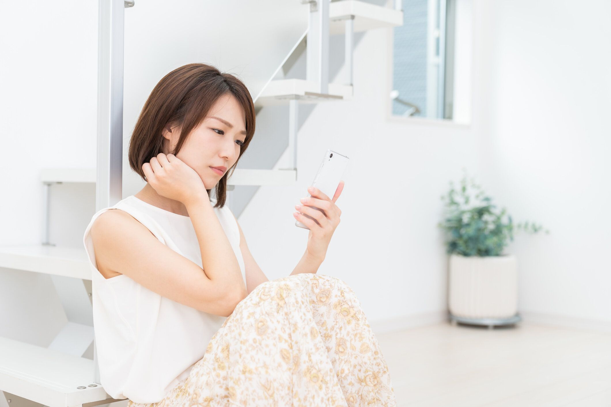スマートフォンを使用して魅力的なアジアの女性、考える、
