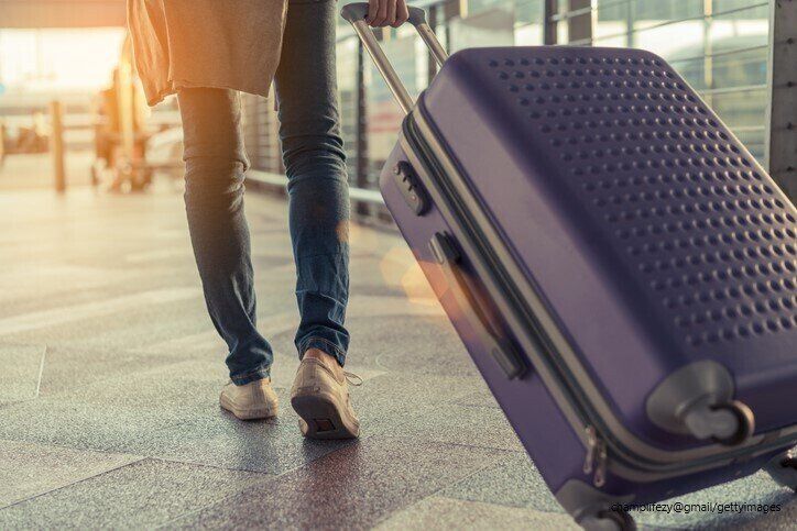 旅行かばんを引く人