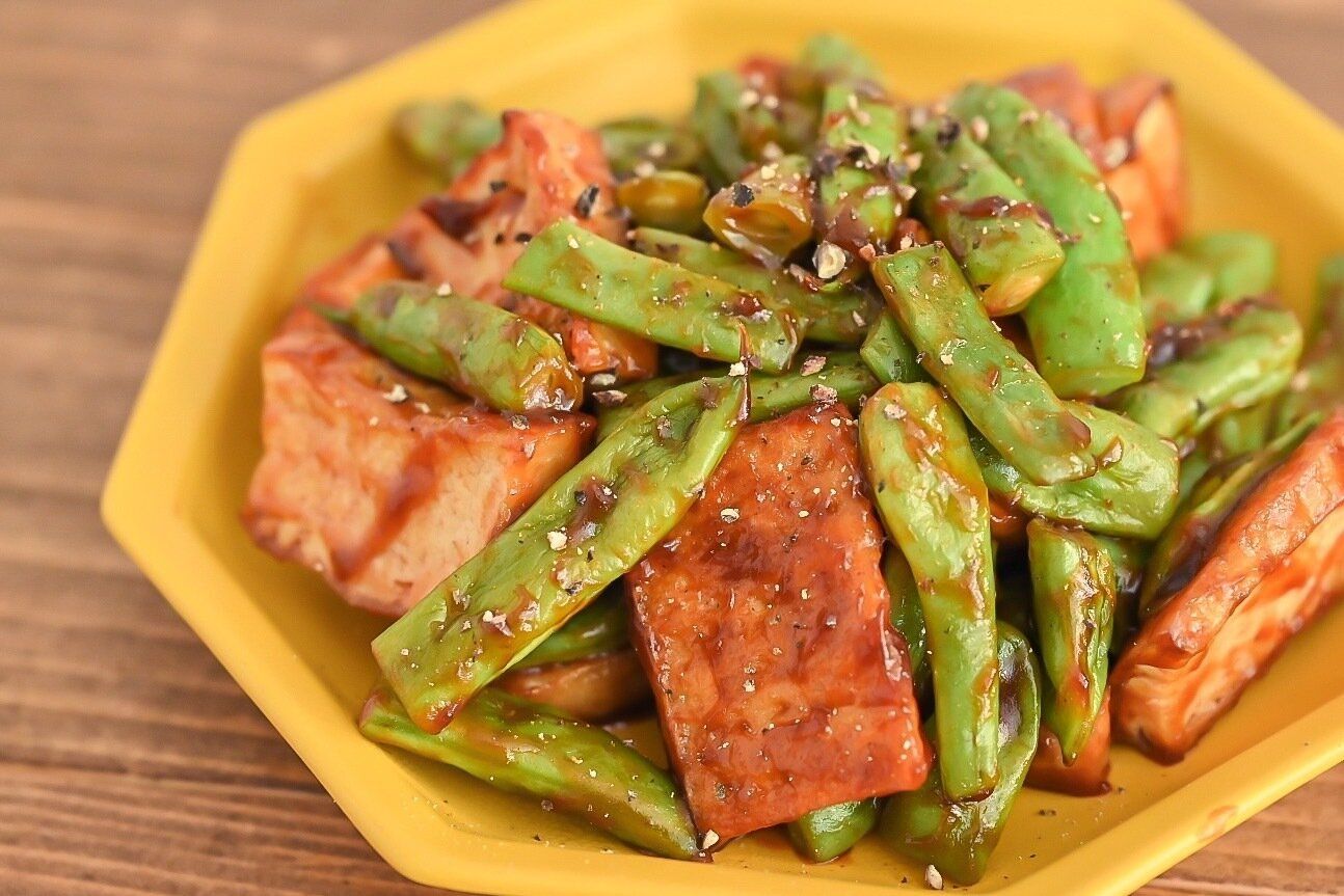 黄色の皿に盛られた厚揚げといんげんのバーベキューソース炒め