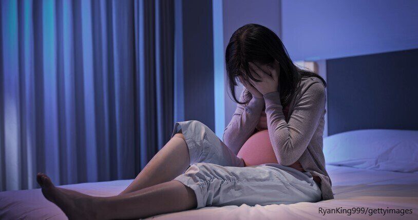 ベッドで悩む女性