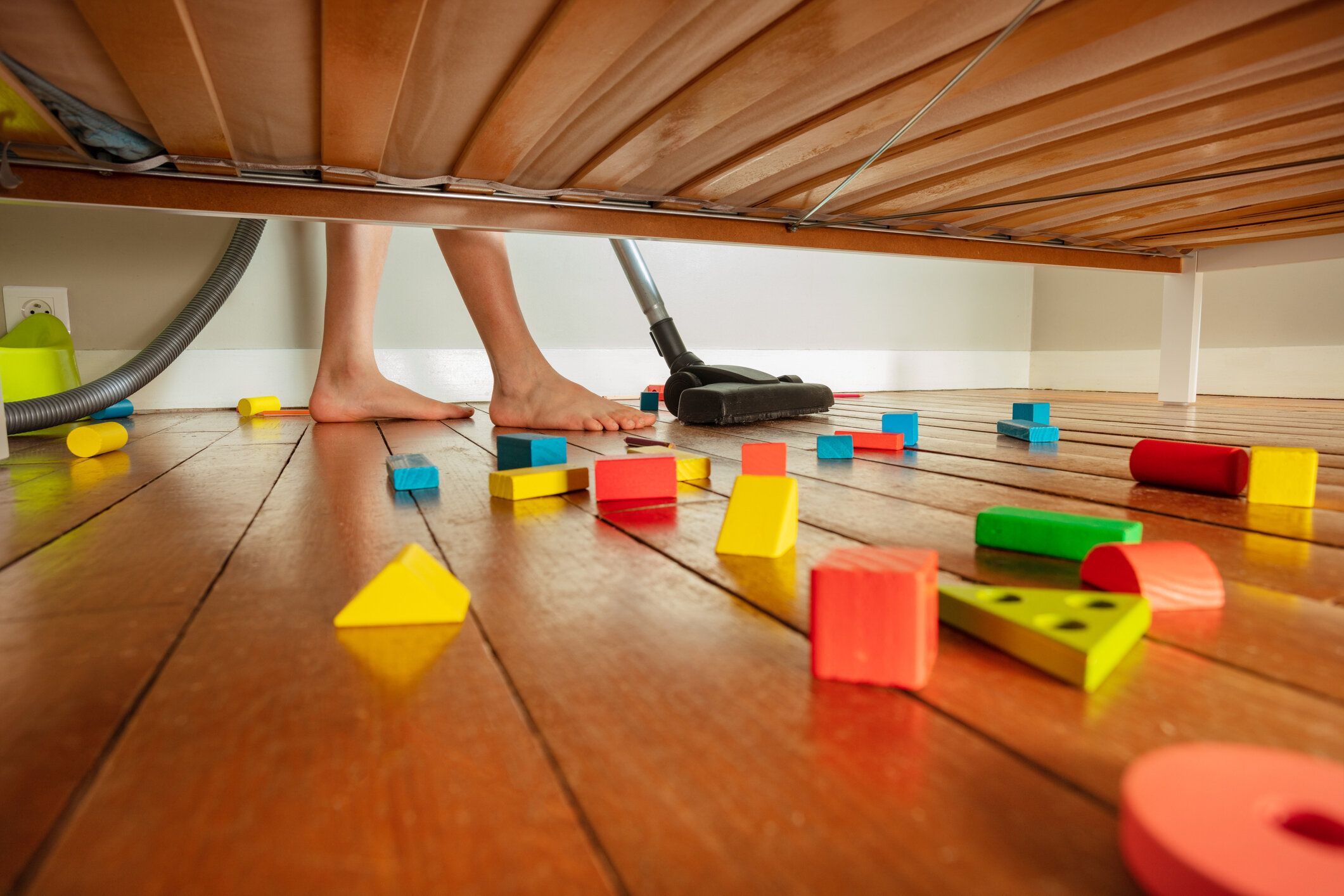 ベッドの下で混乱と男の子のきれいな床の足