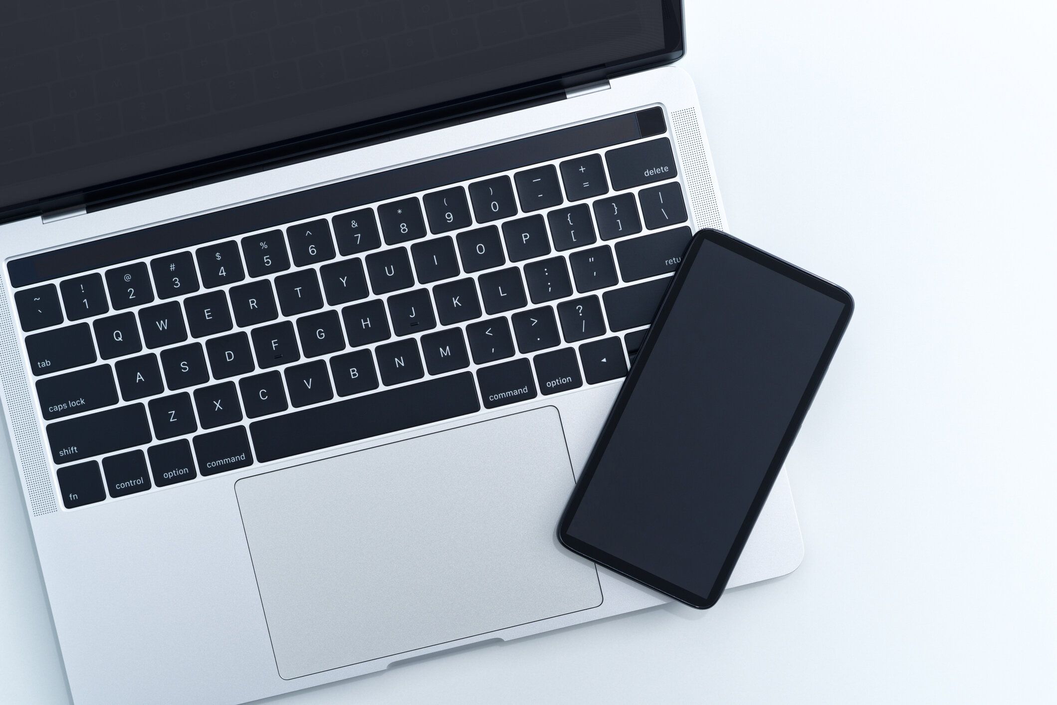 上から白い背景にスマートフォンやノートパソコン。